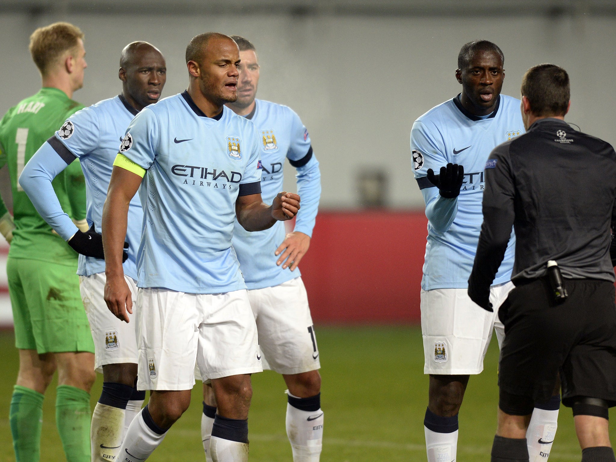 Manchester City players argue with the referee following the penalty decision