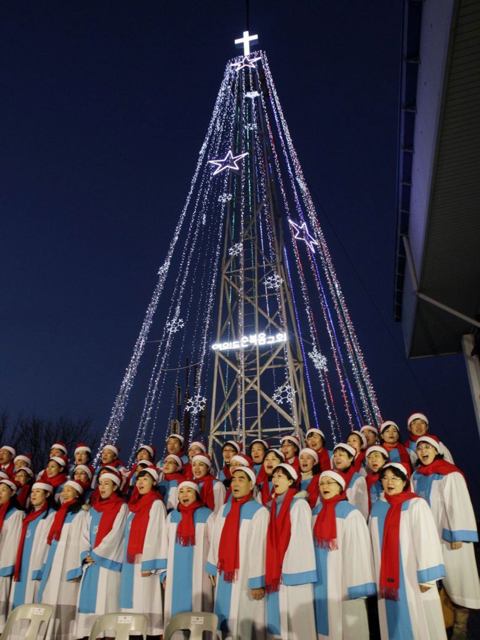 Carol singers at the giant steel Christmas tree at Aegibong in Gimpo, South Korea, in 2010