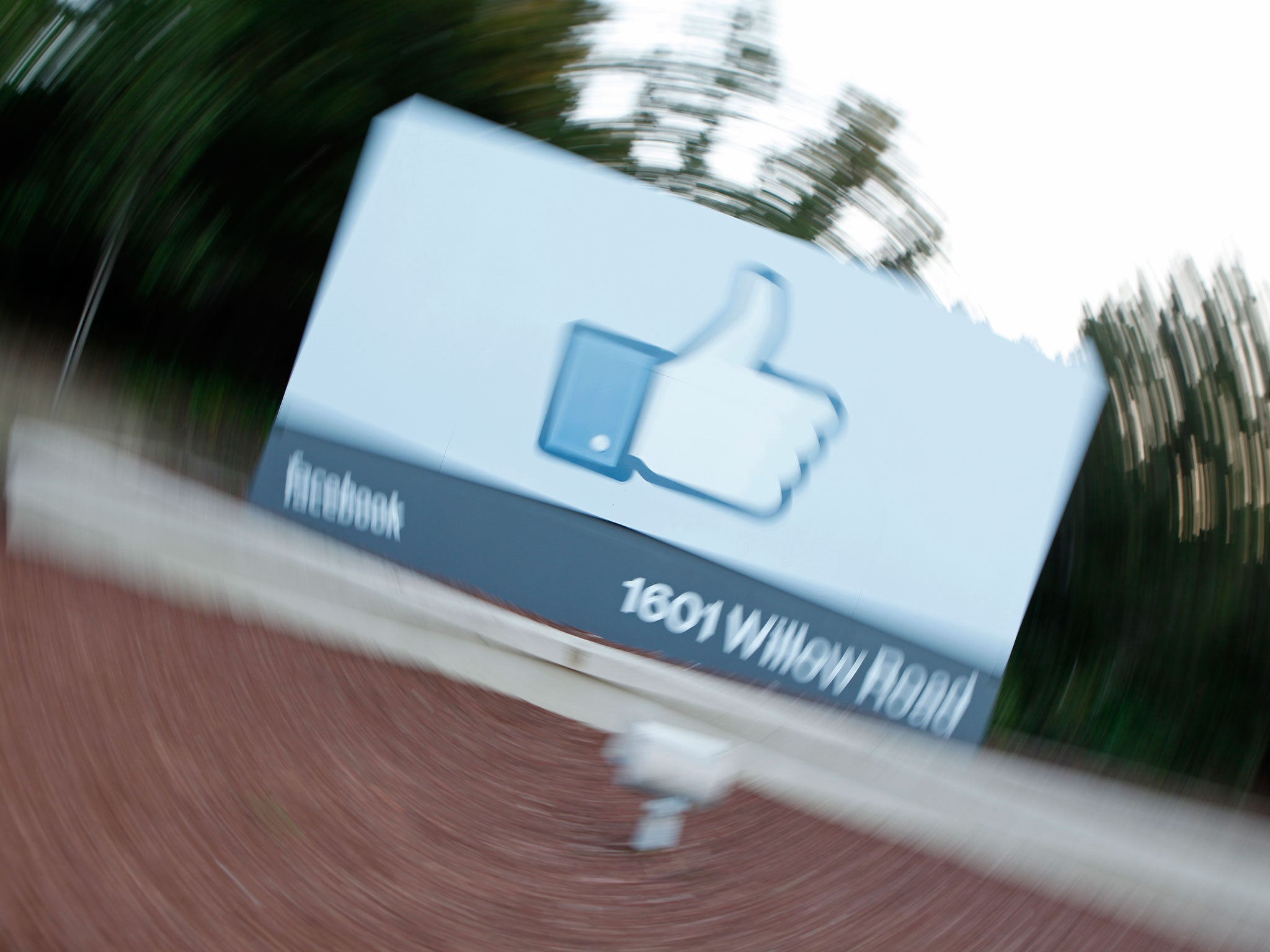 A videographer shoots the side of Facebook's Like Button logo displayed at the entrance of the Facebook Headquarters in Menlo Park, California.