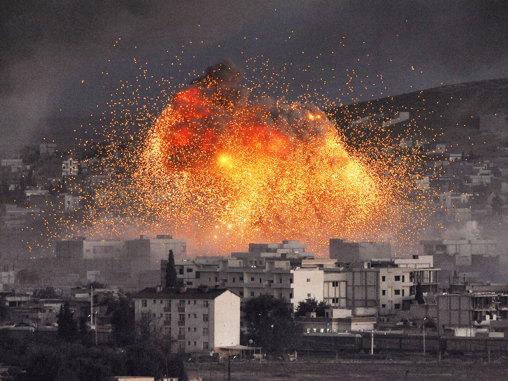 An explosion rocks Syrian city of Kobani during a reported suicide car bomb attack by the militants of Isis group on a People's Protection Unit (YPG) position in the city center of Kobani, as seen from the outskirts of Suruc, on the Turkey-Syria border