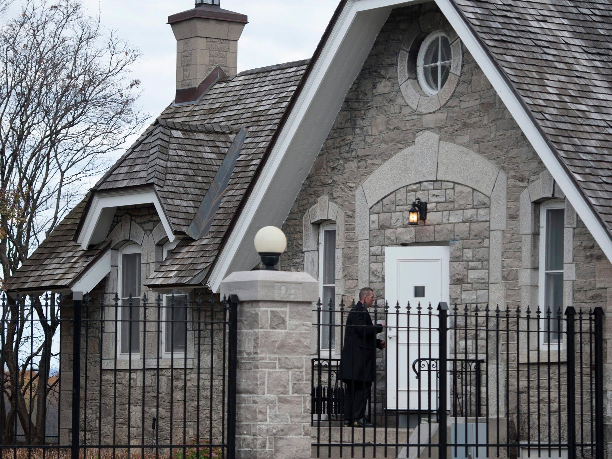 A heavily armed RCMP officer enters 24 Sussex Dr., the official residence of the Prime Minister