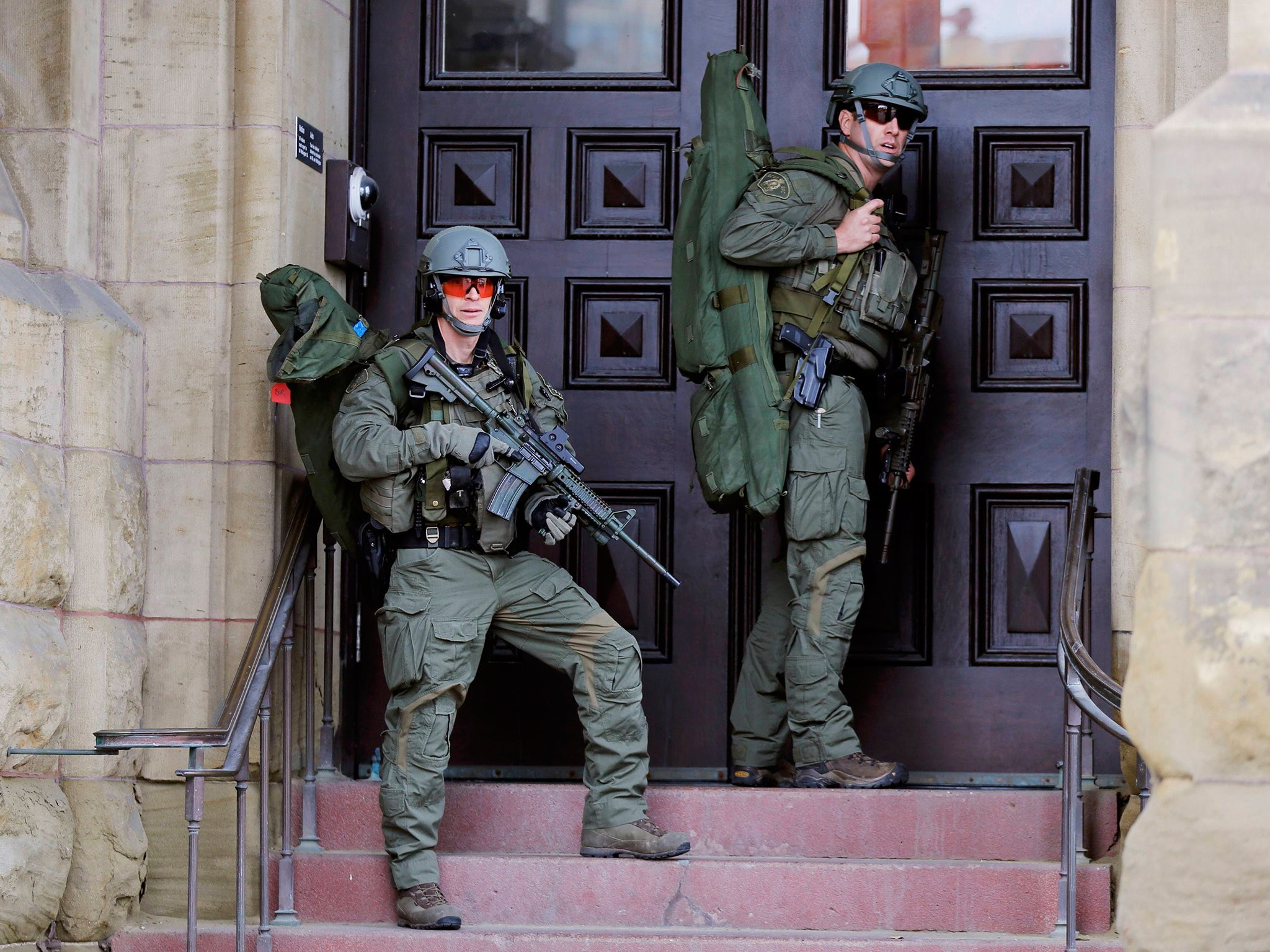 Armed RCMP officers guard the front of Langevin Block on Parliament Hilll following a shooting incident in Ottawa