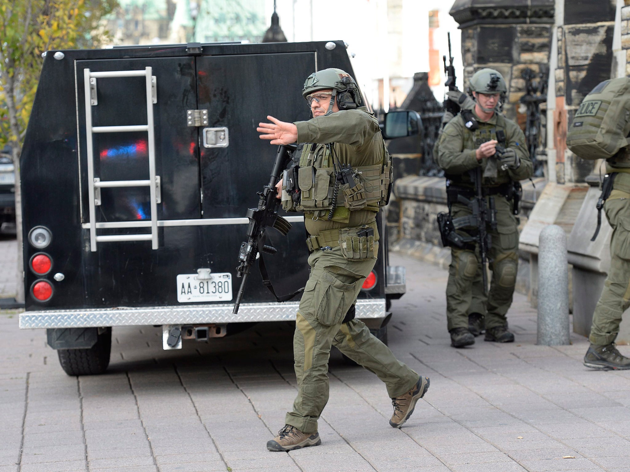RCMP intervention team members clear the area at the entrance of Parliament hill in Ottawa
