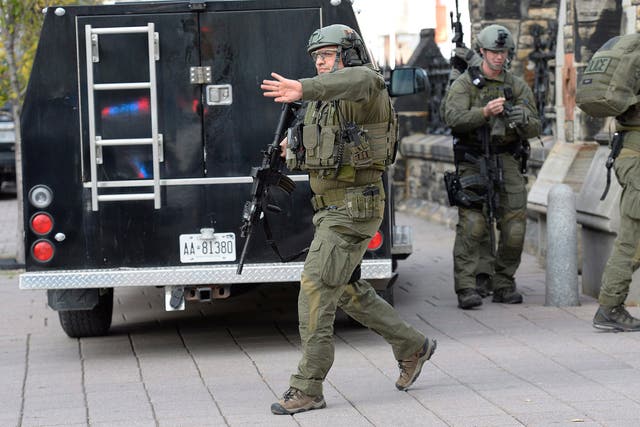 RCMP intervention team members clear the area at the entrance of Parliament hill in Ottawa 