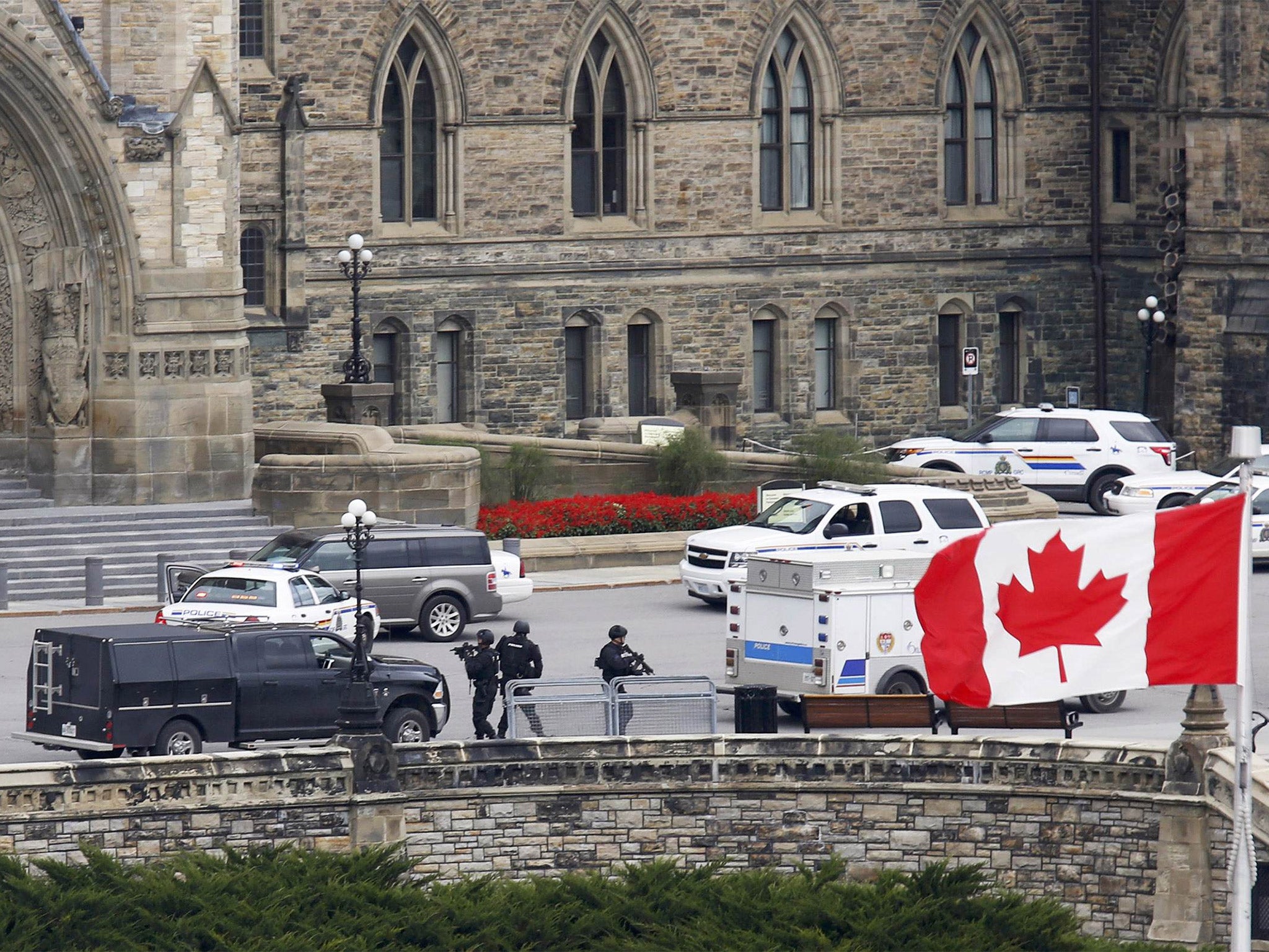 Armed RCMP officers approach Centre Block on Parliament Hilll