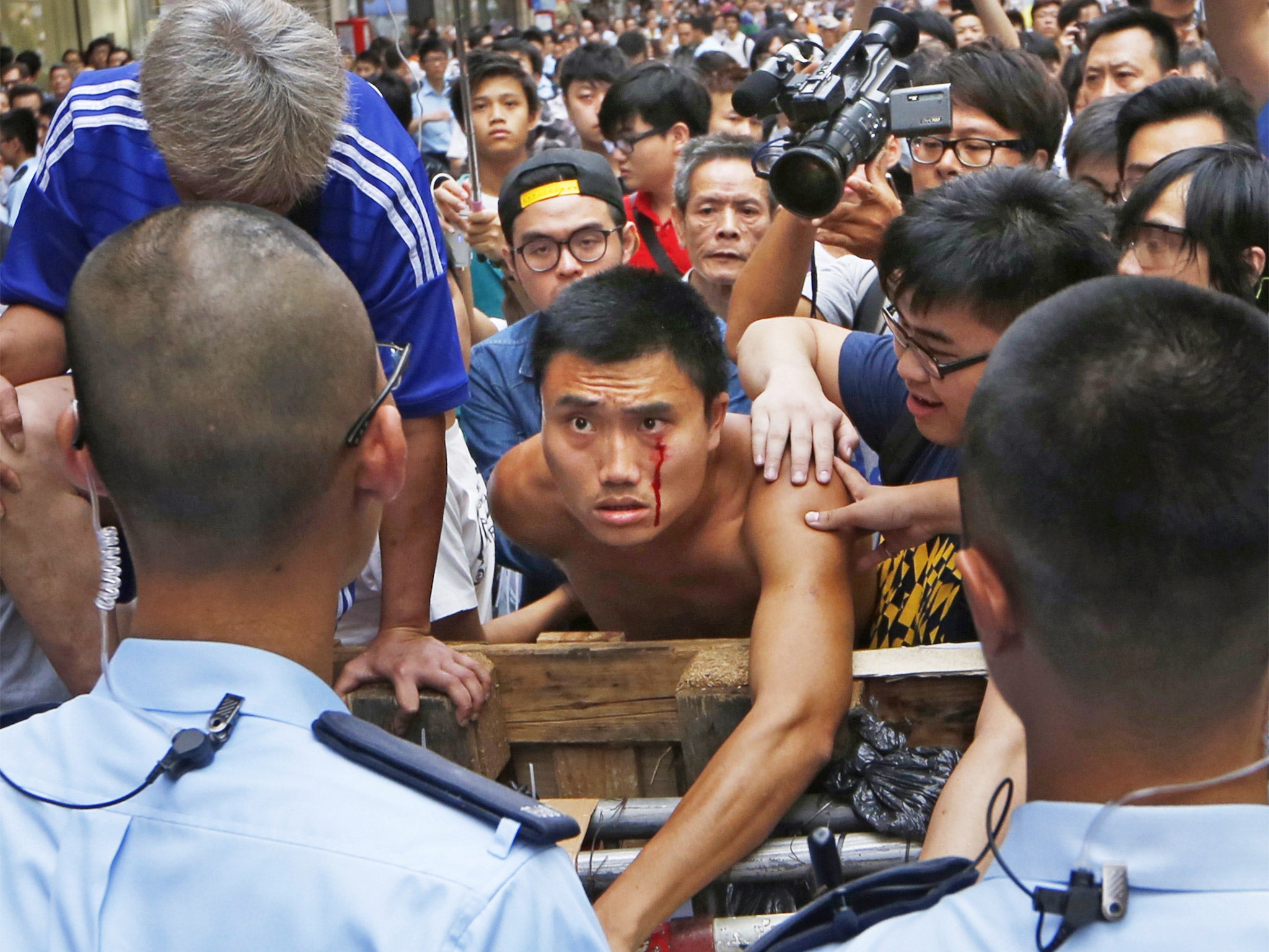Police try to calm a clash between protesters and taxi drivers at a barricade in the Mong Kok district