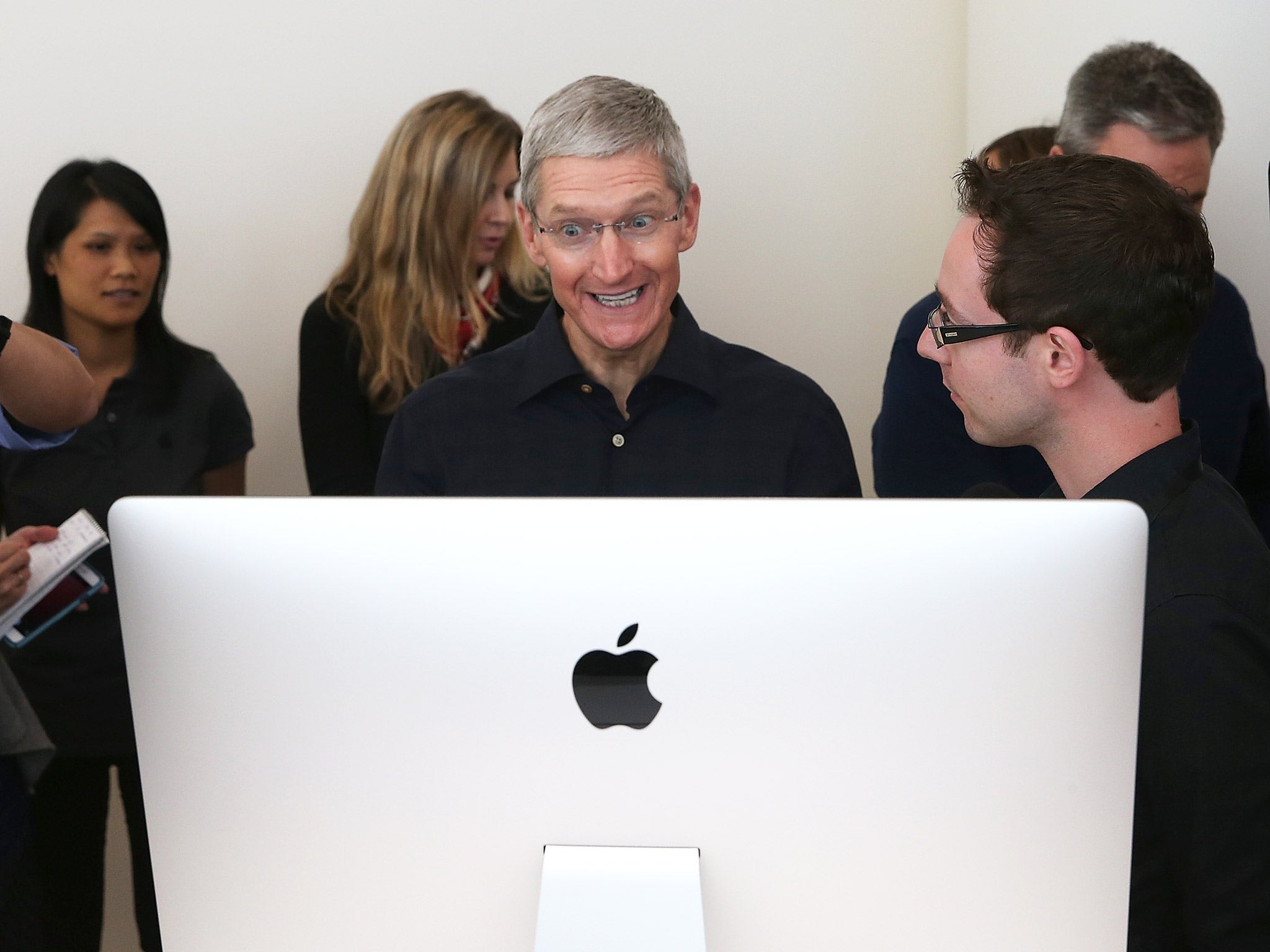 Apple CEO Tim Cook looks at the new 27 inch iMac
