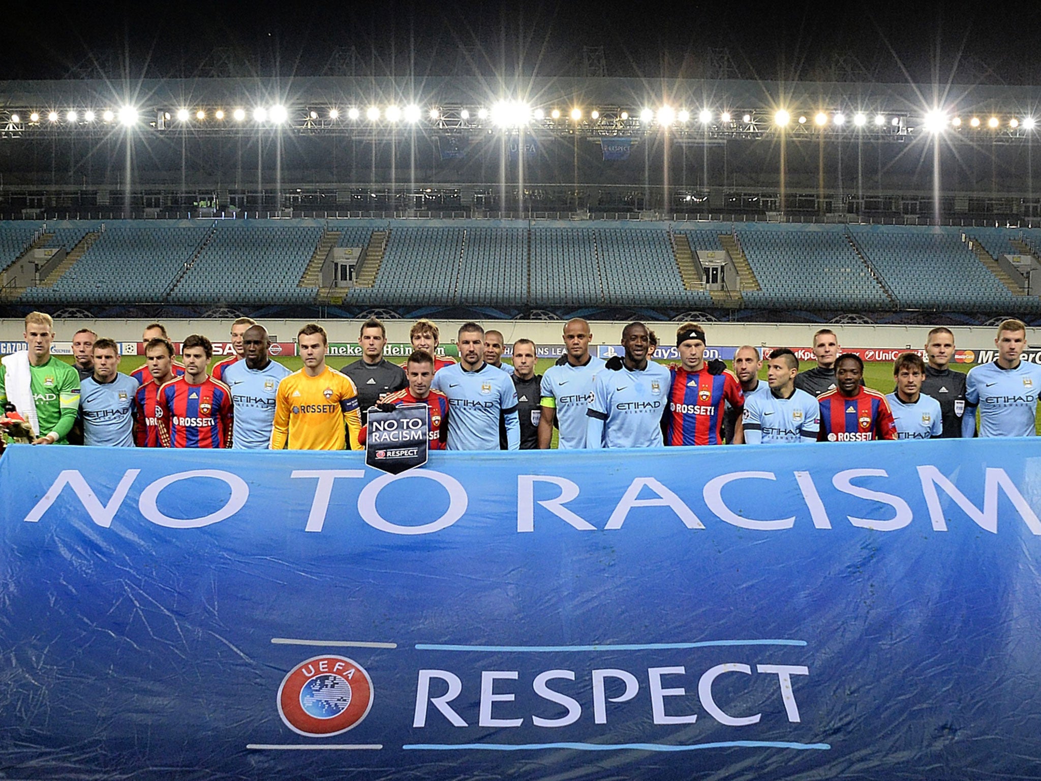 Manchester City and Moscow players line up behind an anti-racism banner at the Khimki Stadium on Tuesday