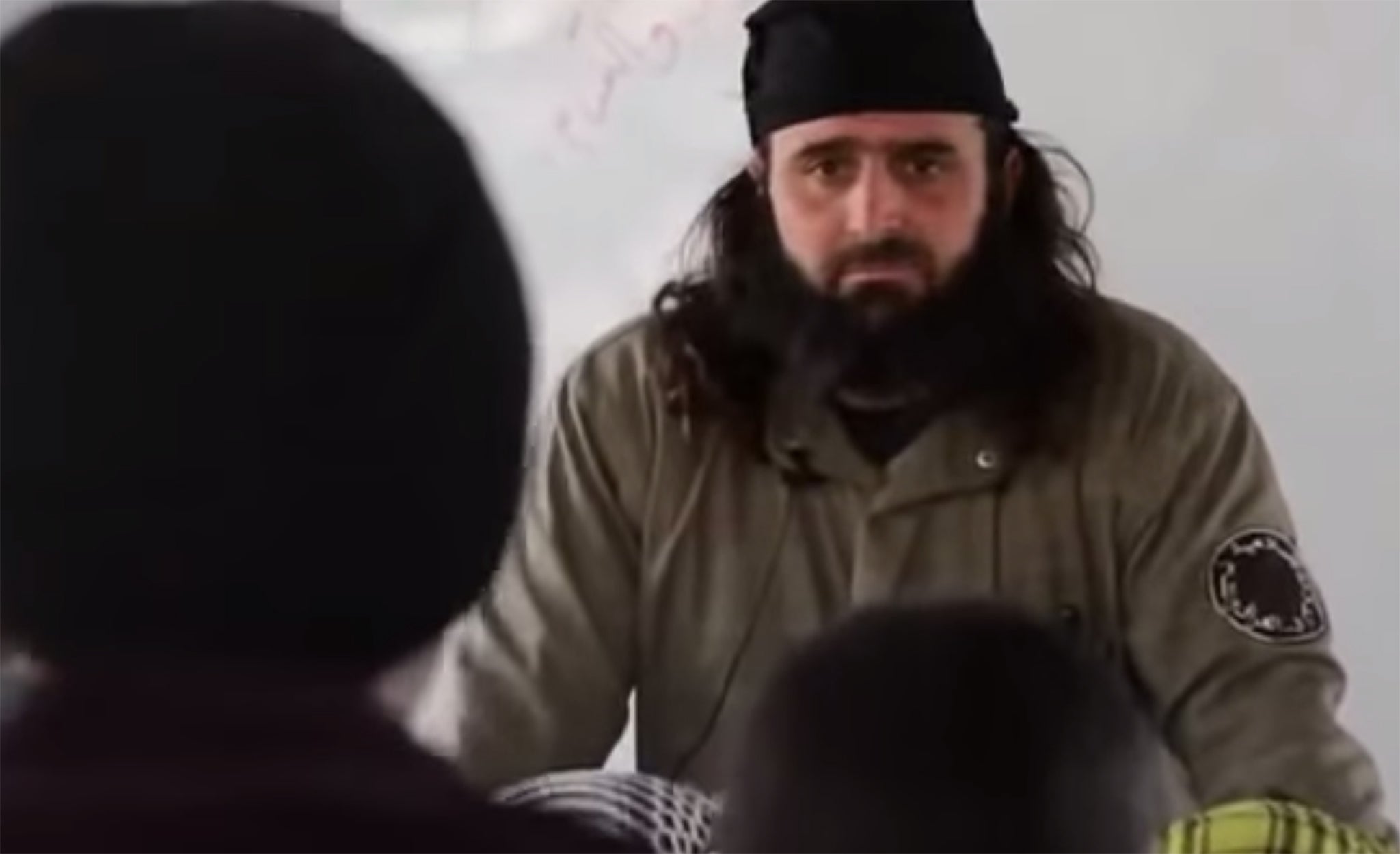 The boys' apparent teacher asks them questions about the tenets of Islam