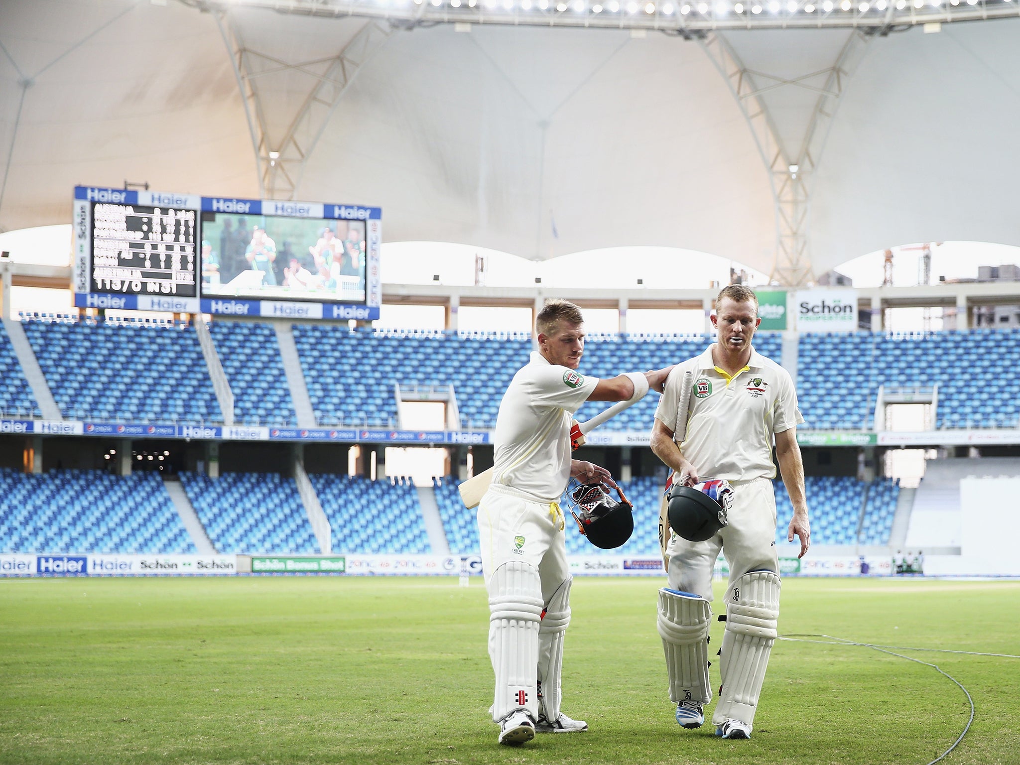 David Warner (left) and Chris Rogers leave the field after helping Australia to a solid start to their innings in Dubai yesterday