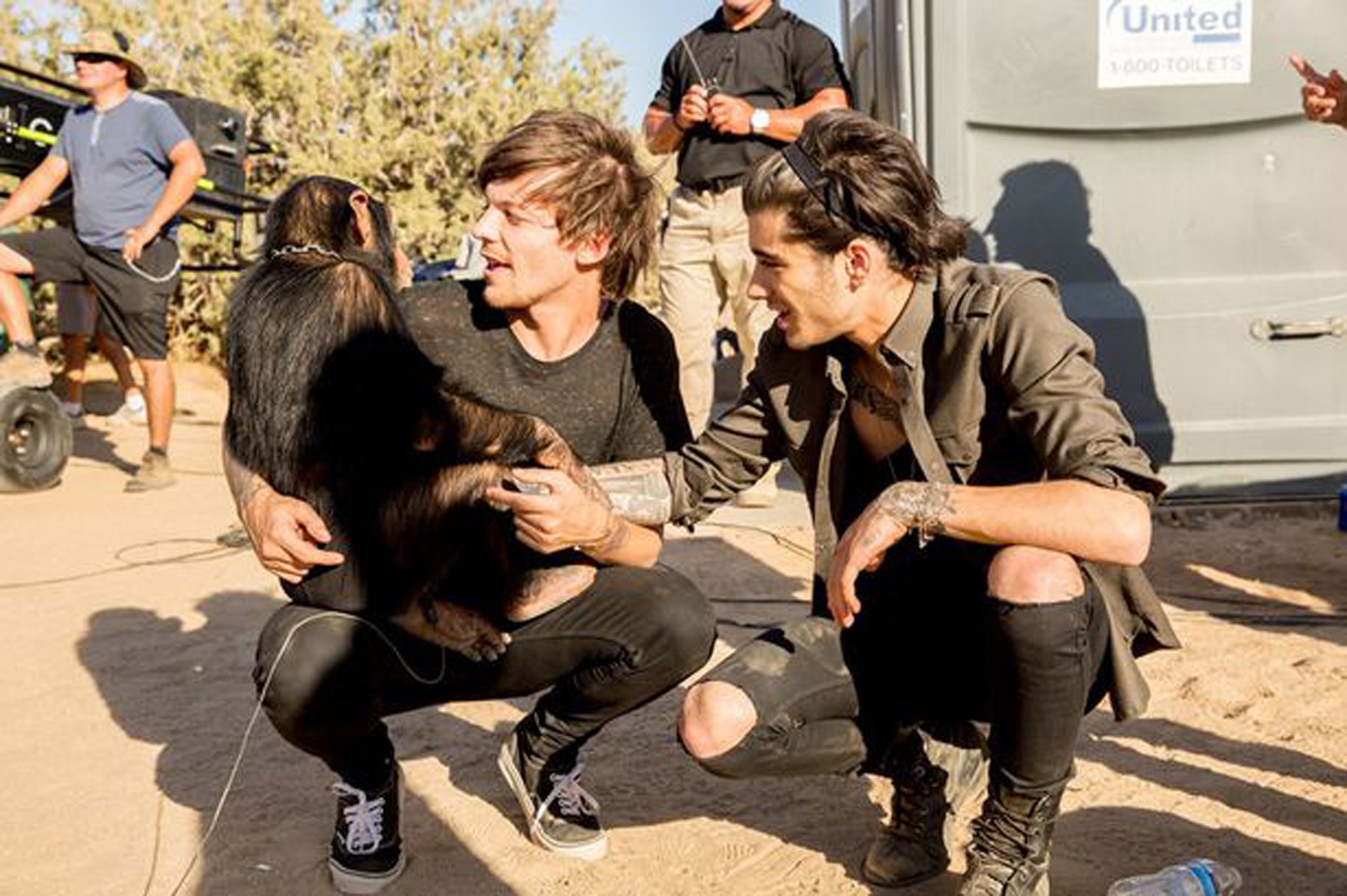 Liam and Zayn of One Direction play with a chimpanzee on the set of their new video for 'Steal My Girl'