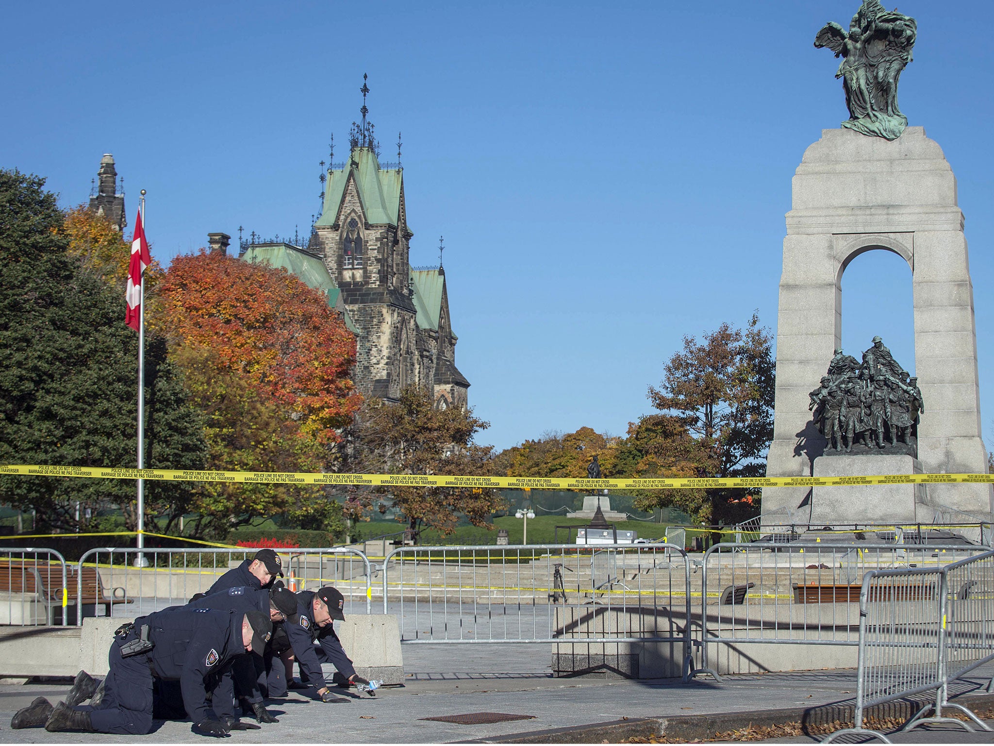 Police officers search the area in front of National War Memorial on October 23, 2014, in Ottawa.