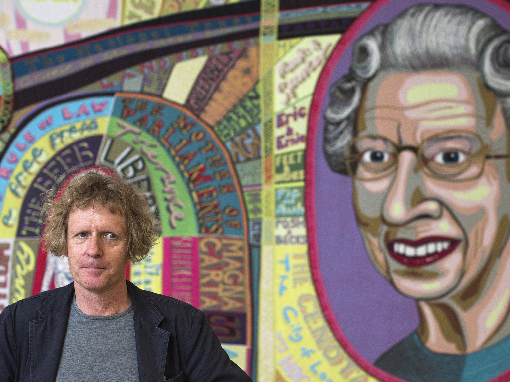 Artist Grayson Perry stands in front of a piece of his entitled 'Comfort Blanket'