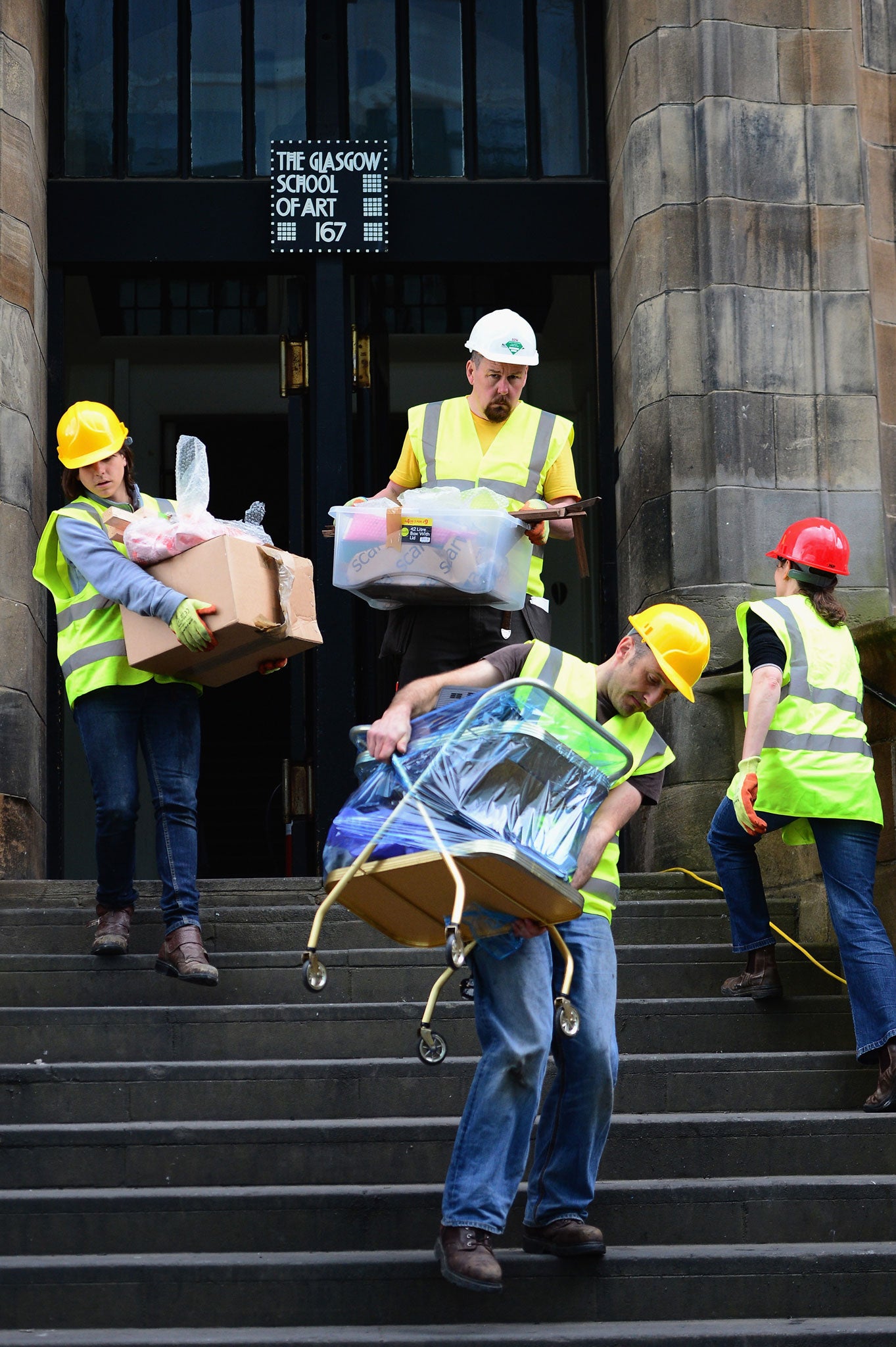 Workers are pictured retrieving student art work from the building after the fire