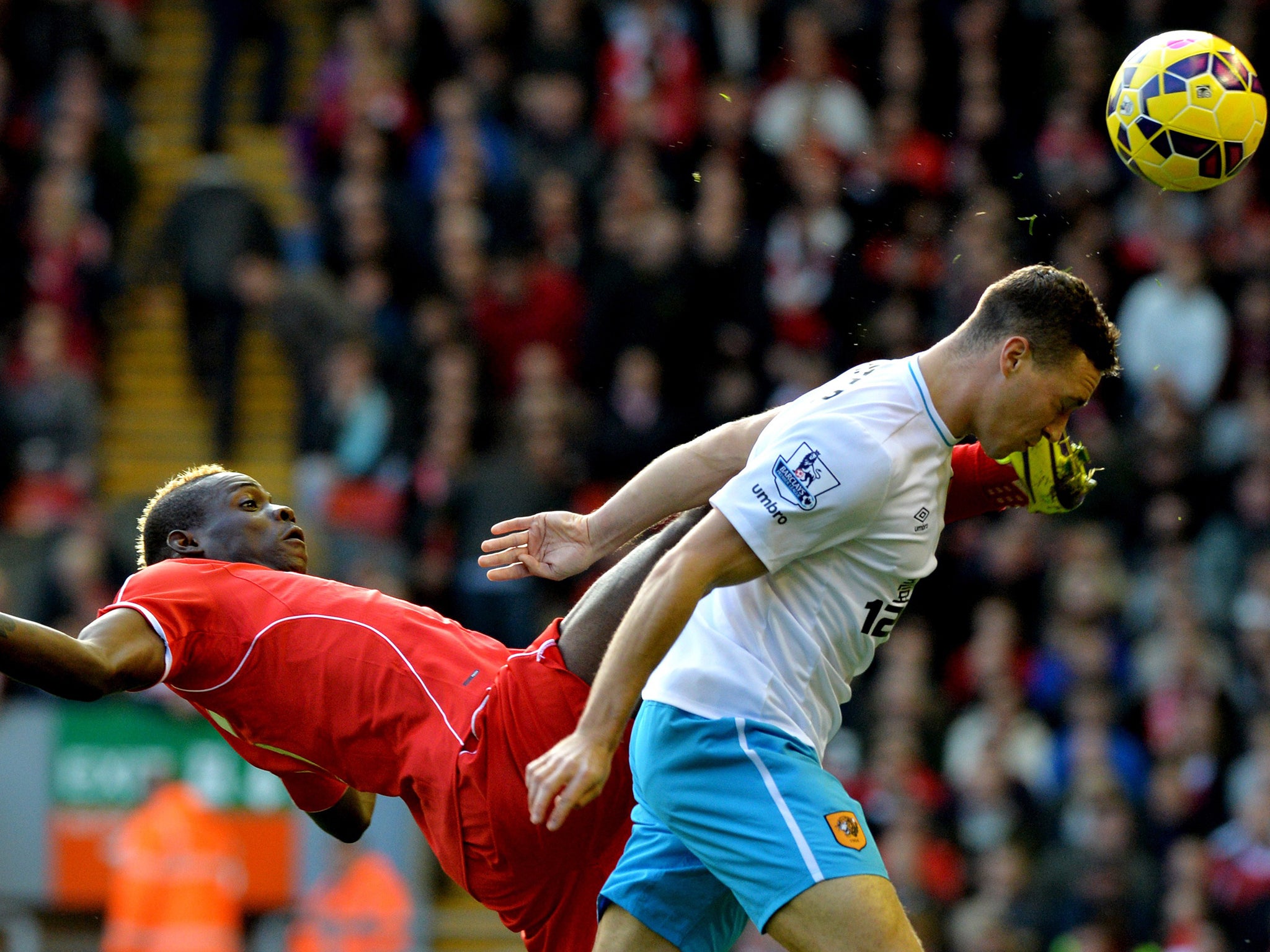 Liverpool's Italian forward Mario Balotelli (L) vies for the ball with with Hull City's English defender James Chester