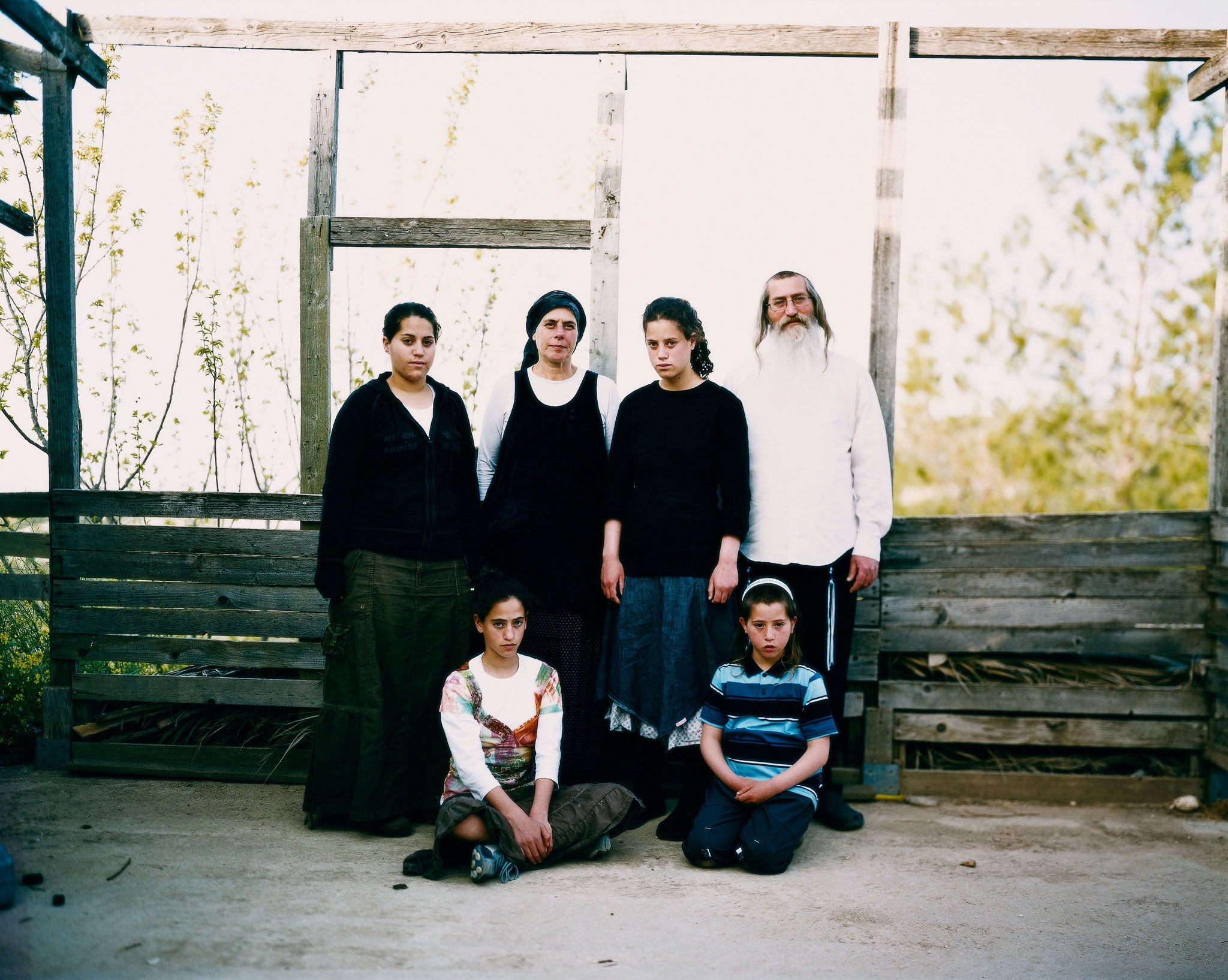 'This is Bat Ayin; the wooden structure the family are standing in front of is for the Sukkot festival: for seven days the family must eat outside'