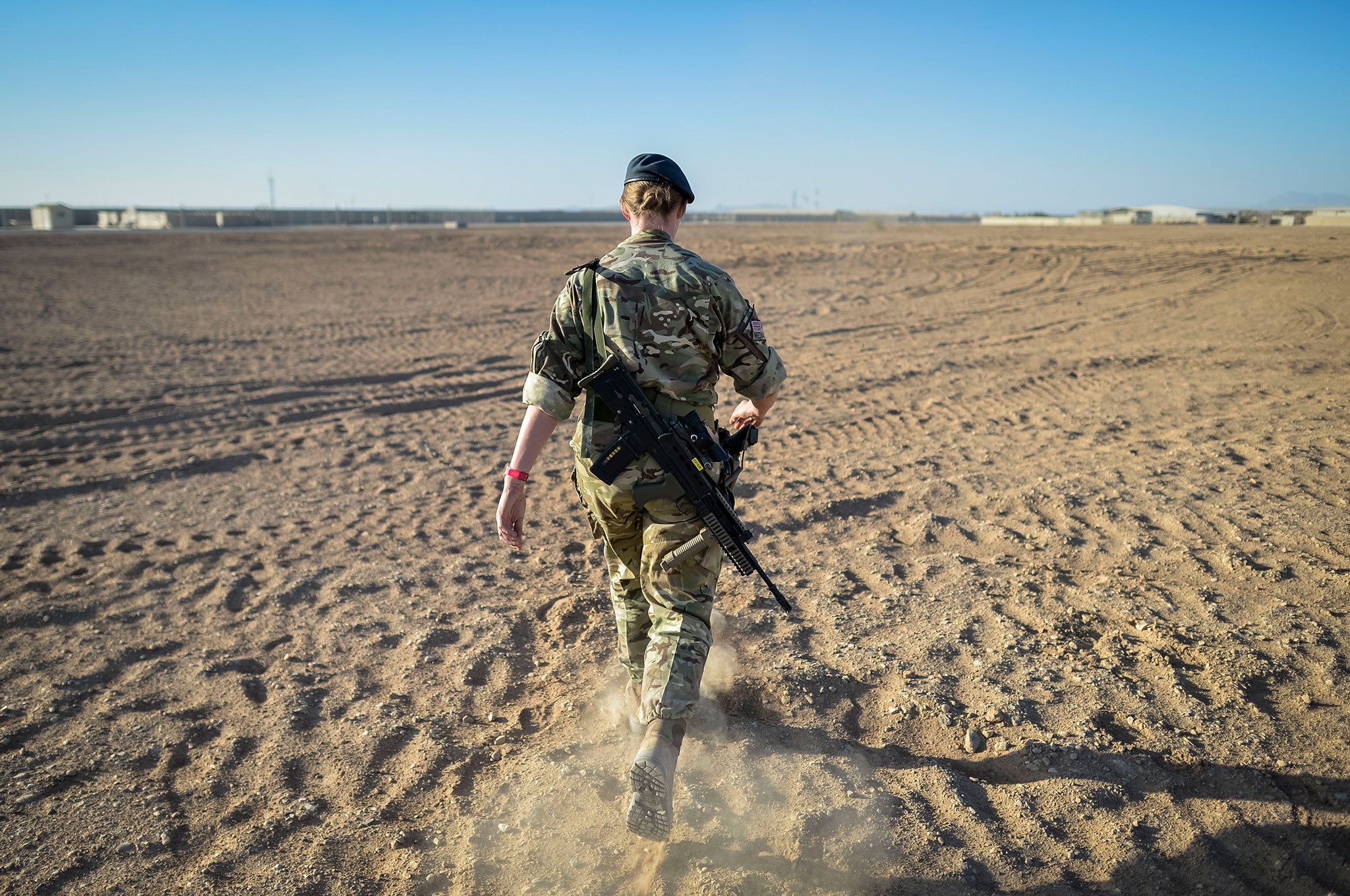 A British officer walking on deserted ground inside Camp Bastion, Helmand Province