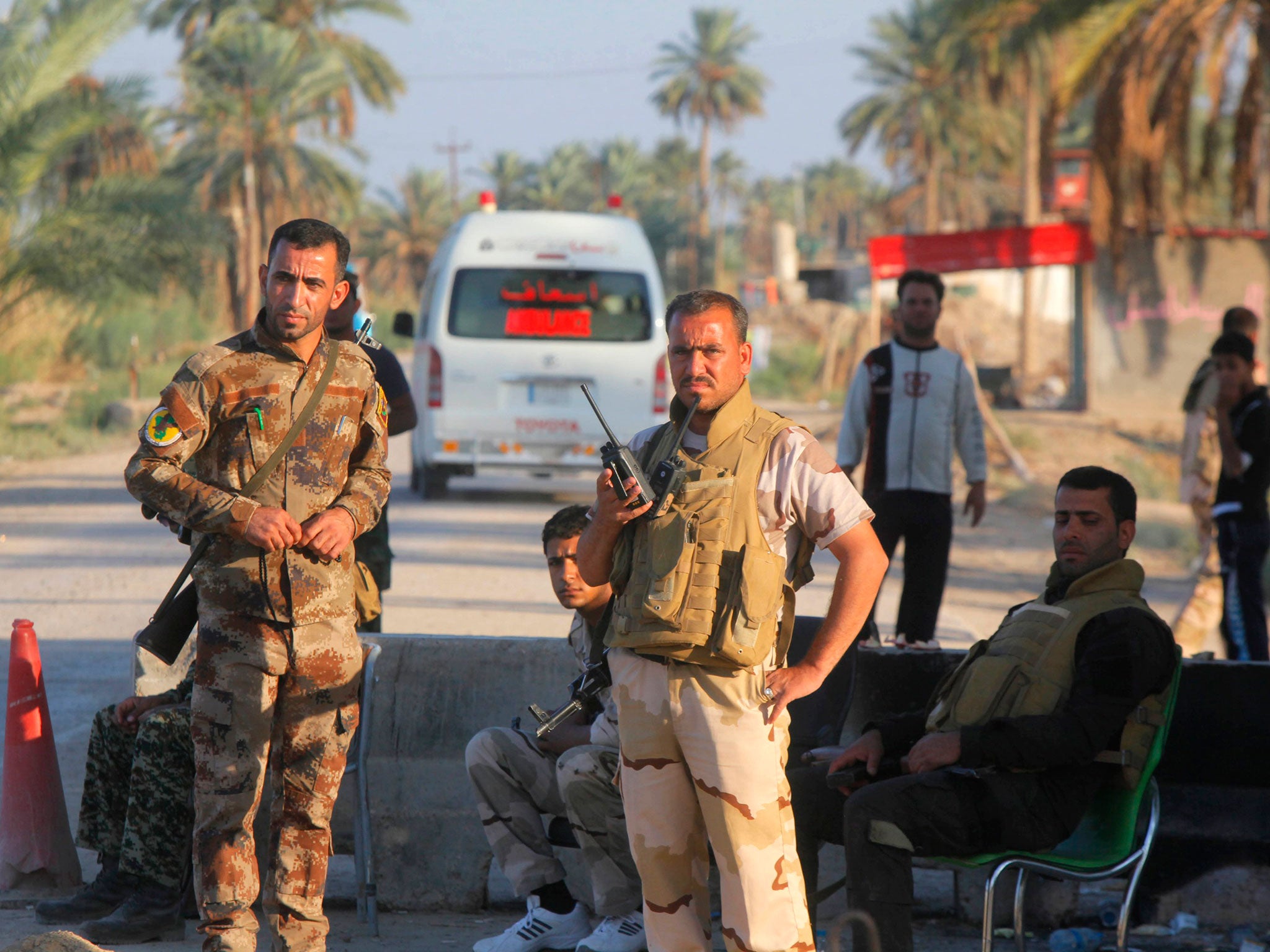 Shi'ite fighters and Iraqi army members guard a checkpoint in Jurf al-Sakhar