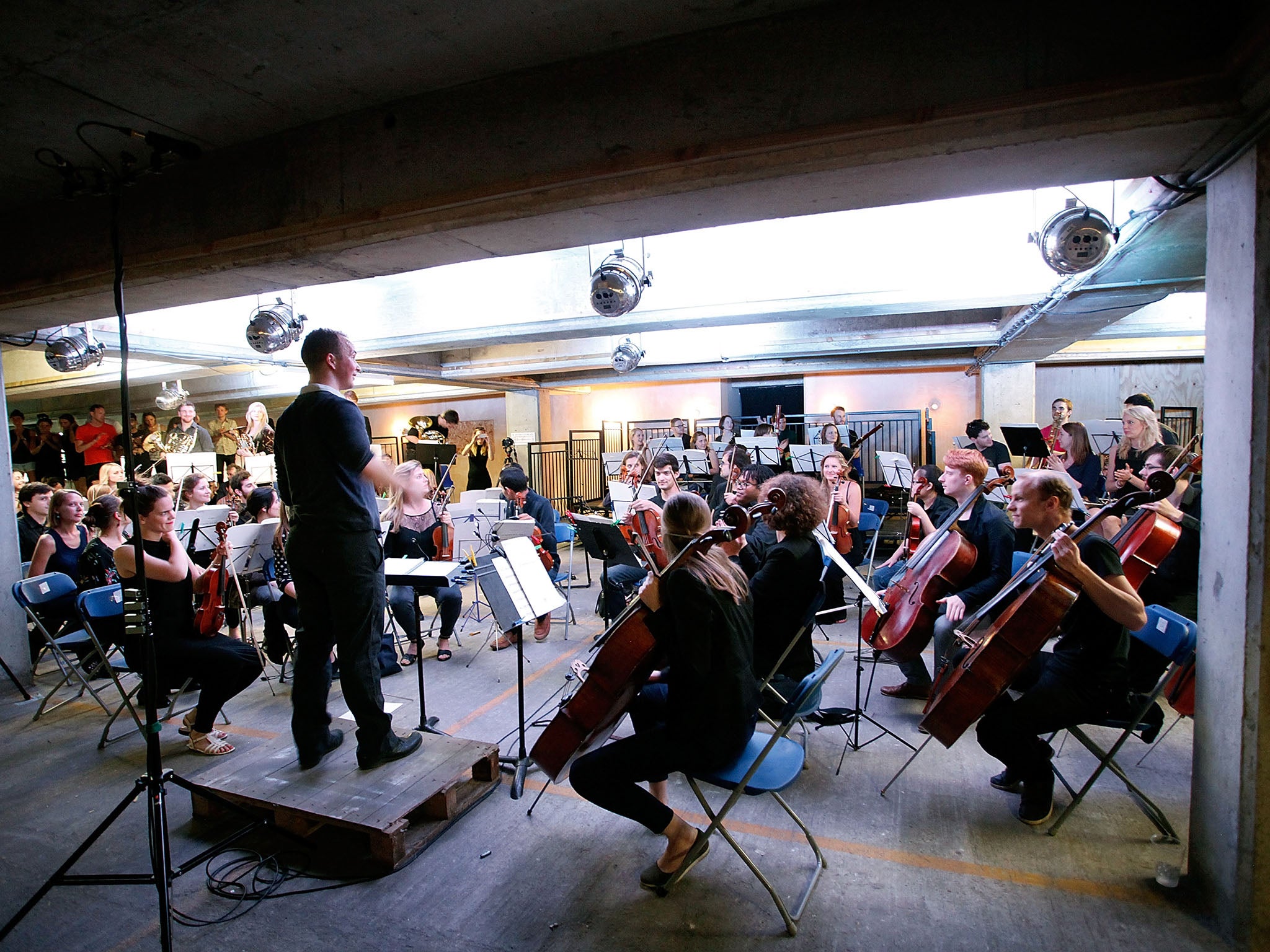 Christopher Stark conducts The Multi-Story Orchestra as they perform Jean Sibelius' 5th Symphony at the Peckham Rye Car Park on June 21, 2014 in London, England. The performance is one of a series that the orchestra will be performing in the South London