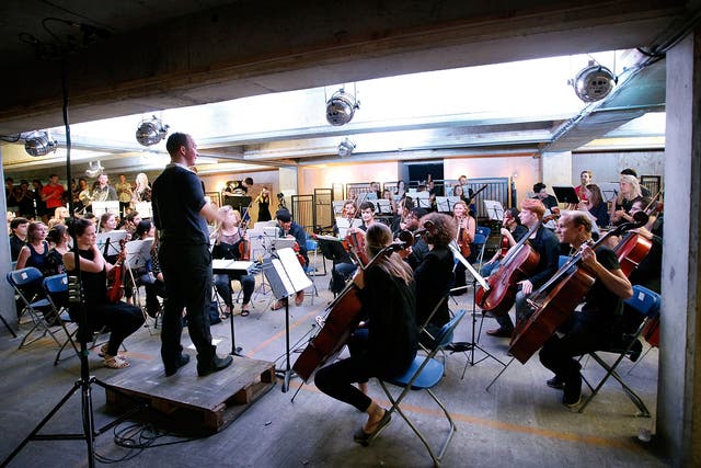 Christopher Stark conducts The Multi-Story Orchestra as they perform Jean Sibelius' 5th Symphony at the Peckham Rye Car Park on June 21, 2014 in London, England. The performance is one of a series that the orchestra will be performing in the South London 