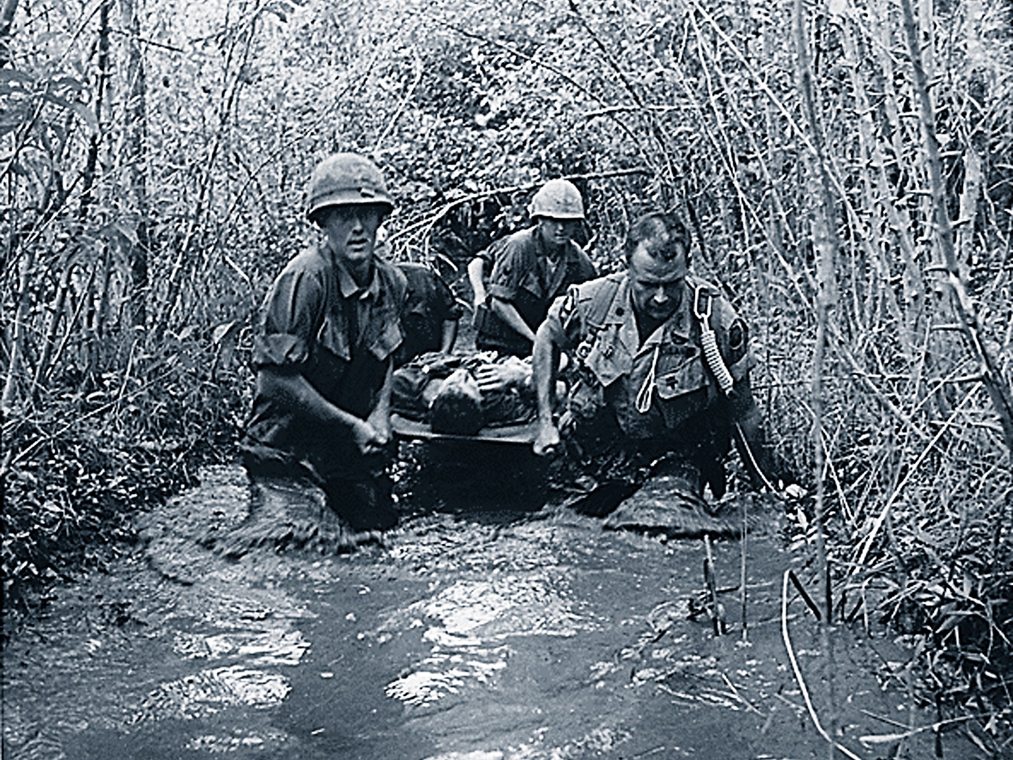 US soldiers carry a wounded comrade through a swampy area during action in Vietnam in 1969.