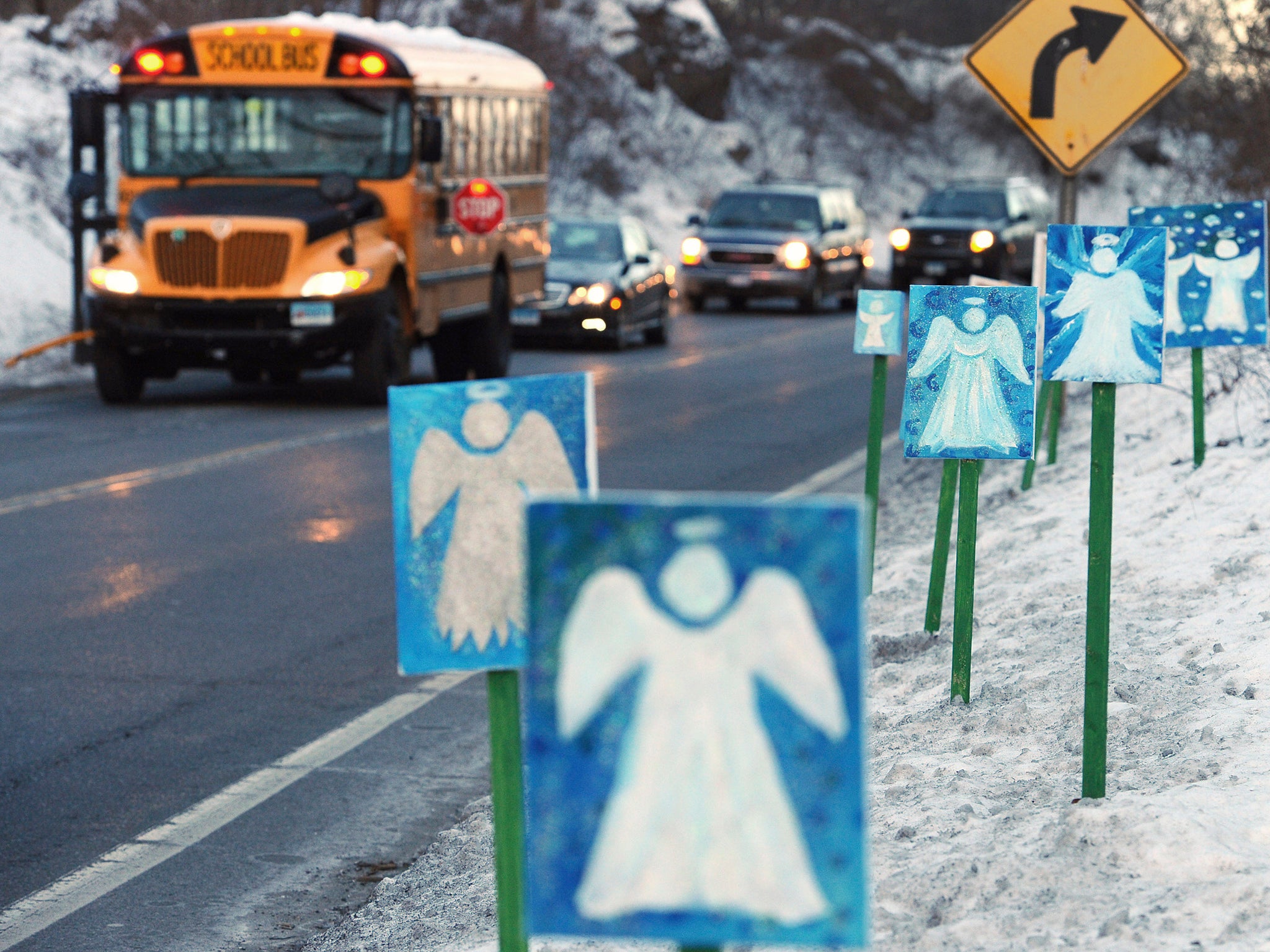 A bus traveling from Newtown to Monroe stops in front of 26 angels along the roadside on the first day of classes for Sandy Hook Elementary School students since the Dec. 14, 2012 shooting.