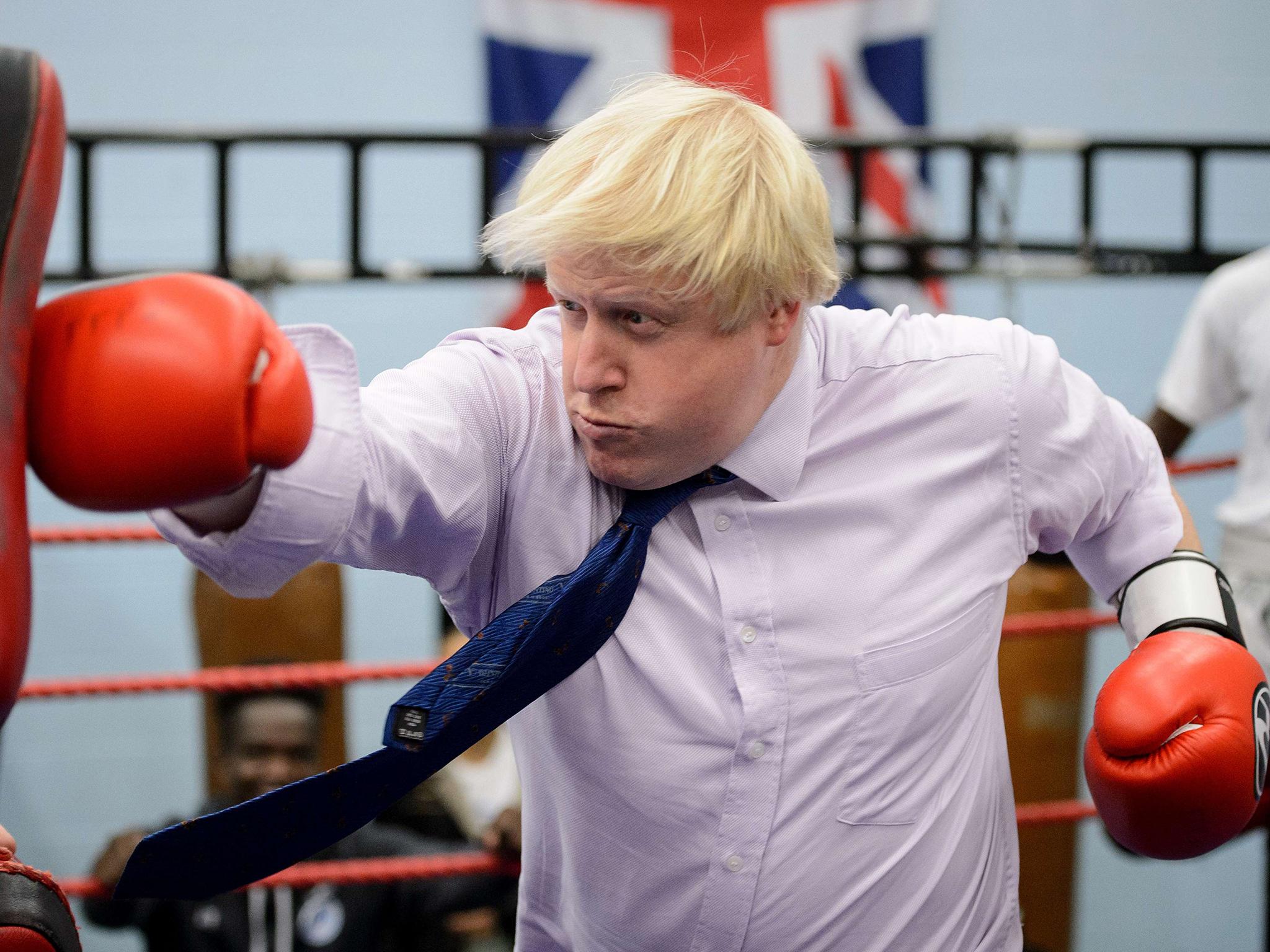 Mayor of London Boris Johnson boxes with a trainer during his visit to Fight for Peace Academy in North Woolwich, London