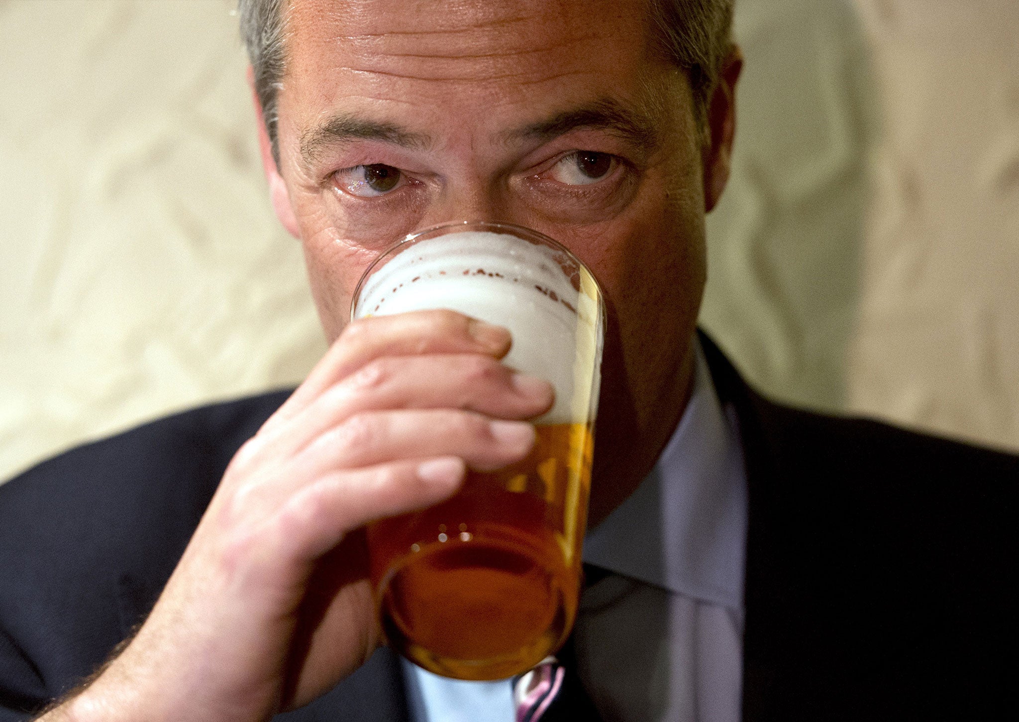 Nigel Farage enjoys a pint of beer after unveiling campaign posters ahead of the Heywood and Middleton by-election