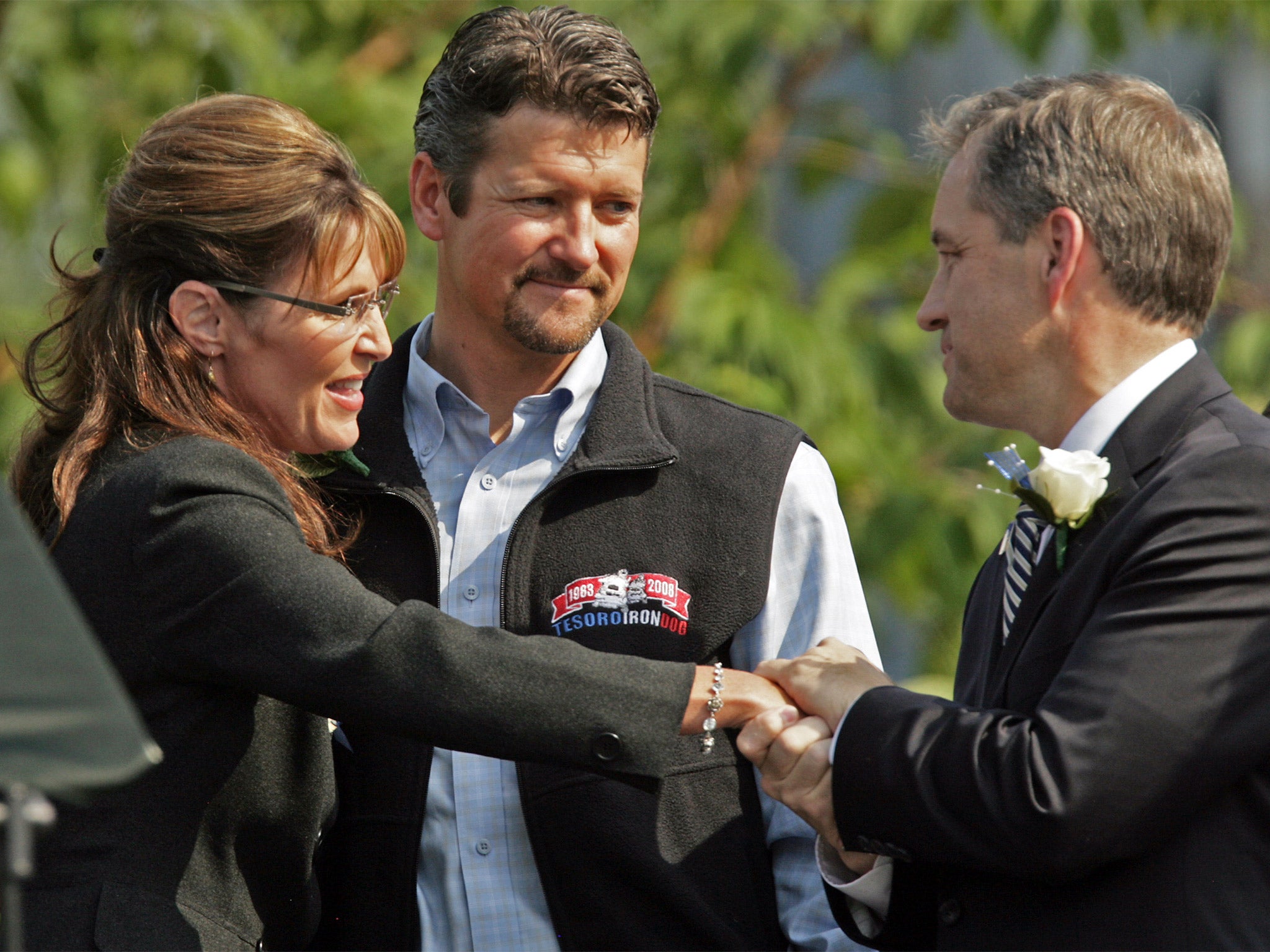 Sarah Palin, left, and her husband Todd, centre, congratulate incoming Governor Sean Parnell in 2009. Palin now opposes him