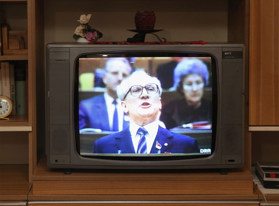 Footage of Erich Honecker delivering a speech is shown on a television in a faithfully-reconstructed typical East German home