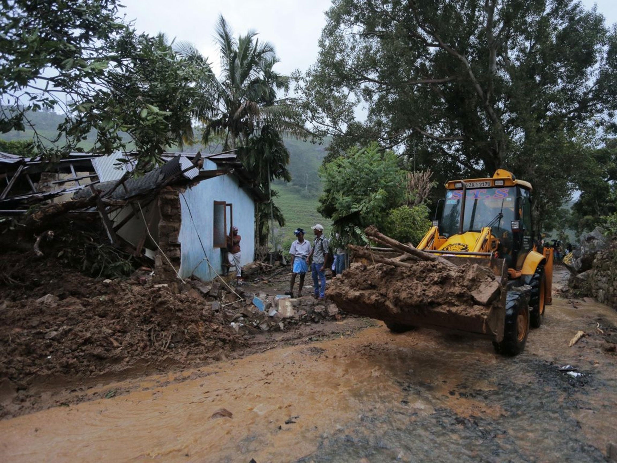 An earthmover clears debris caused by mudslide at the Koslanda tea plantation