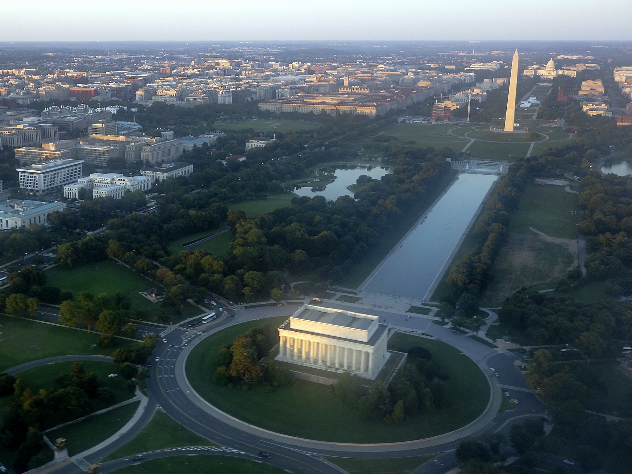 The skyline of Washington, DC, including the Lincoln Memorial, Washington Monument, US Capitol and National Mall, is seen from the air at sunset