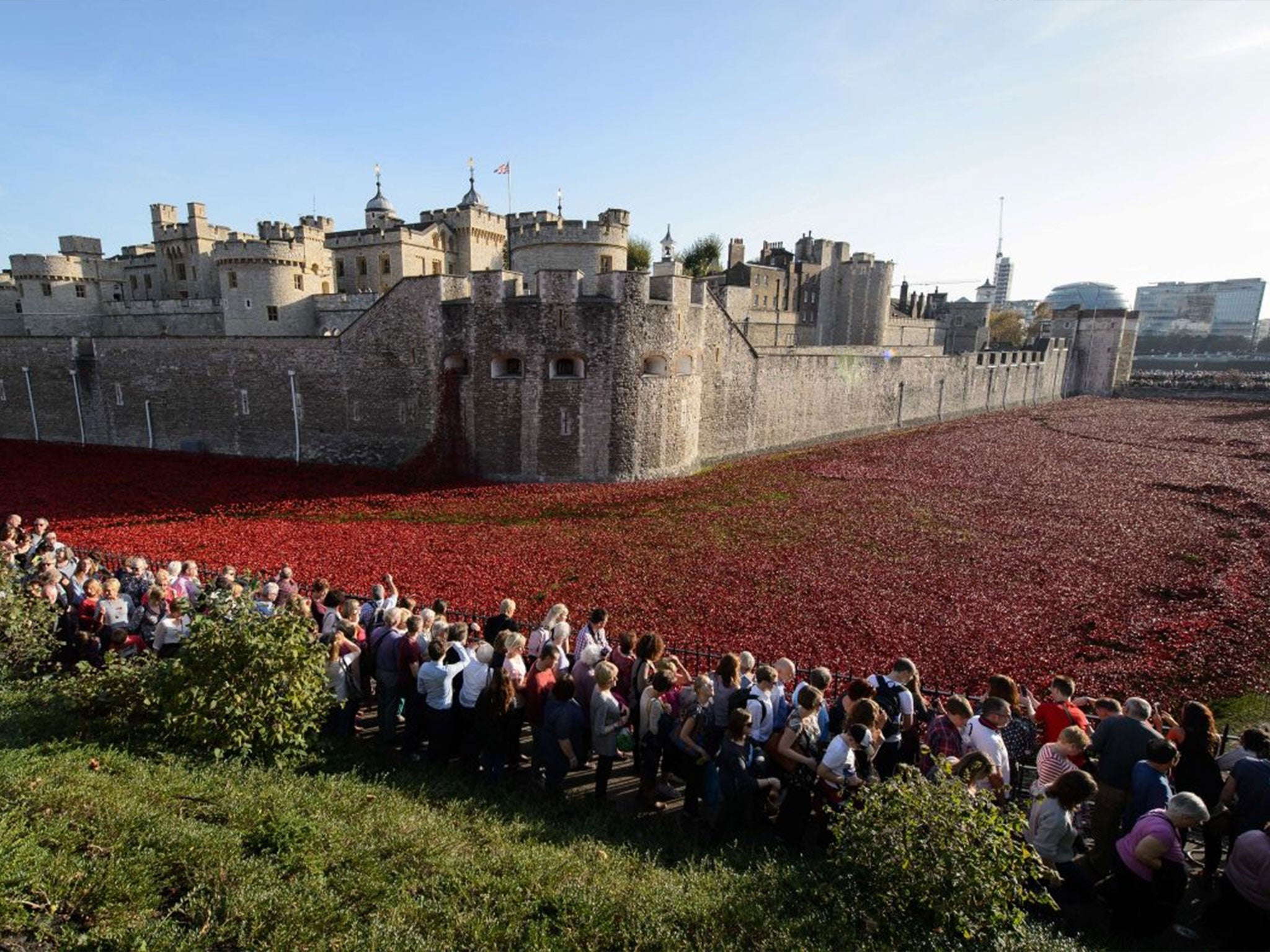 Visitors view the "Blood Swept Lands and Seas of Red" installation by ceramic artist Paul Cummins and theatre stage designer Tom Piper, marking the centenary of the outbreak of the First World War, in the moat area of the Tower of London in central London