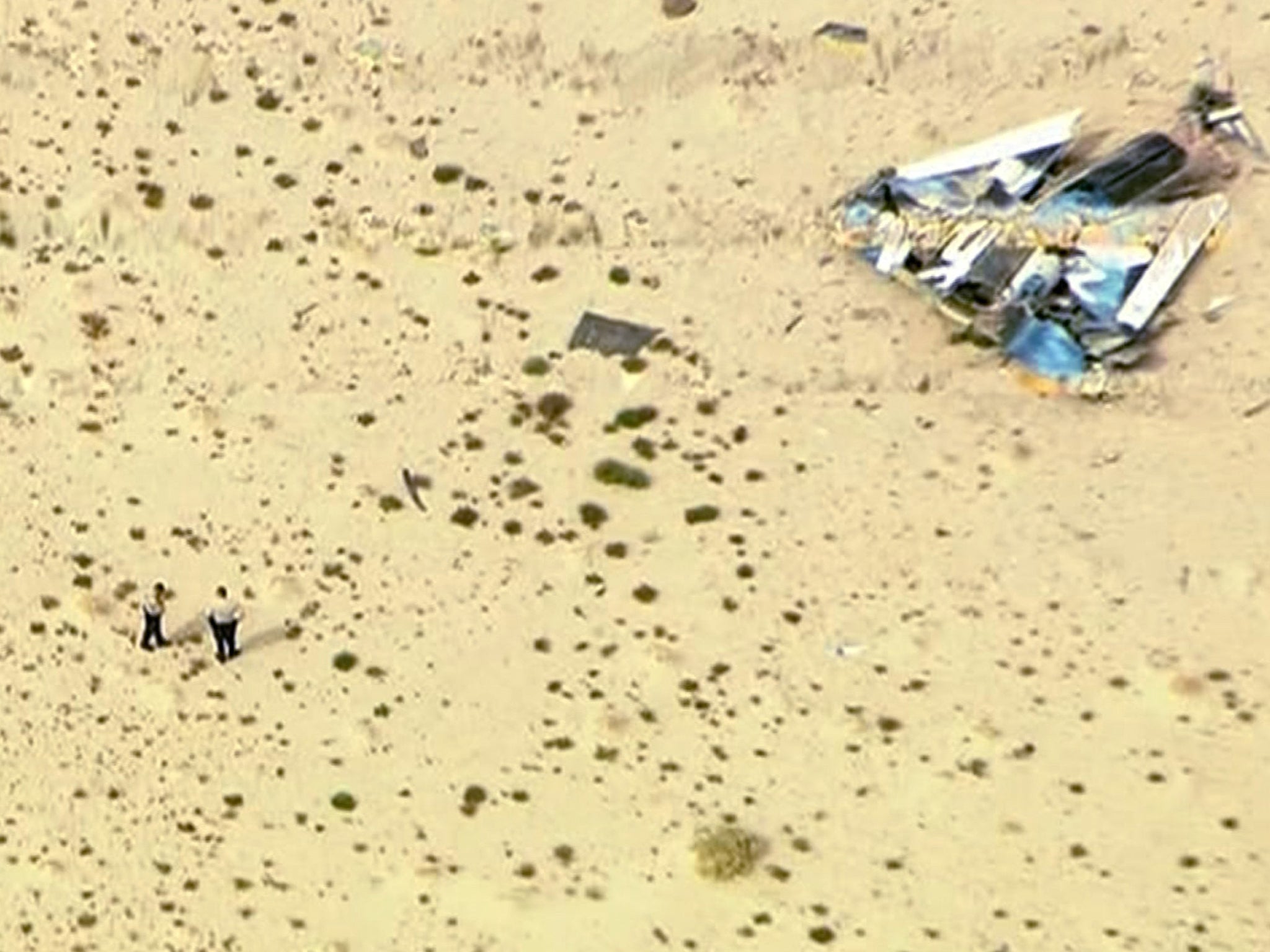 Police officers stand near wreckage from Virgin Galactic's SpaceShipTwo