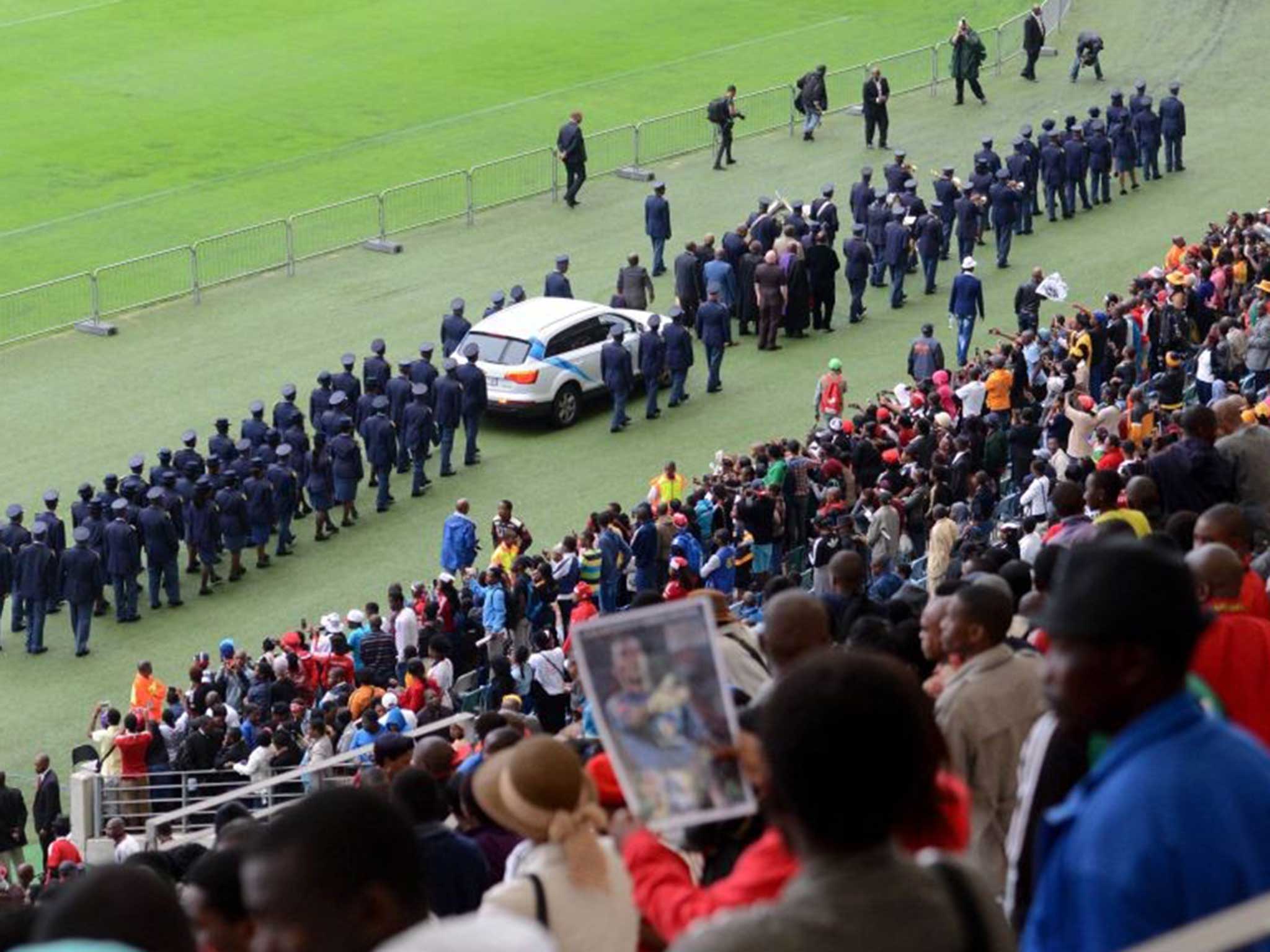 The coffin arriving and being driven around the stadium