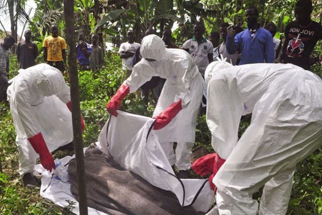 Health workers in Monrovia, Liberia, recover the body of a suspected Ebola victim