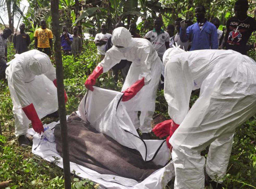 Health workers in Monrovia, Liberia, recover the body of a suspected Ebola victim