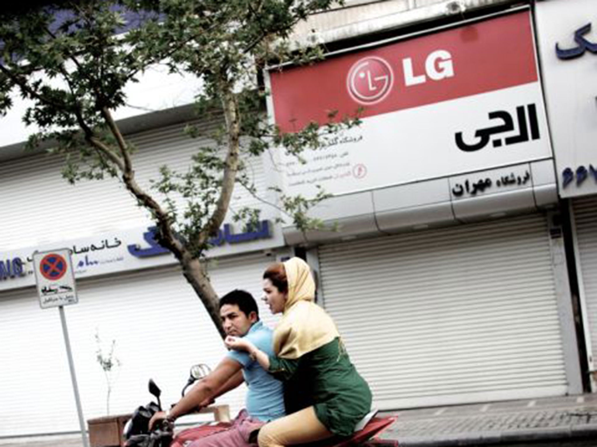 Getting by: mobile phones are advertised on the streets of Iran