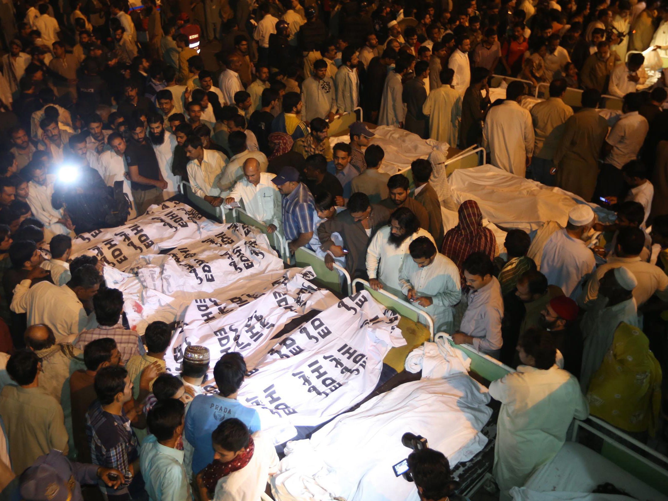 Locals crowd around the bodies of the victims of the suicide bomb attack, at a hospital in Lahore