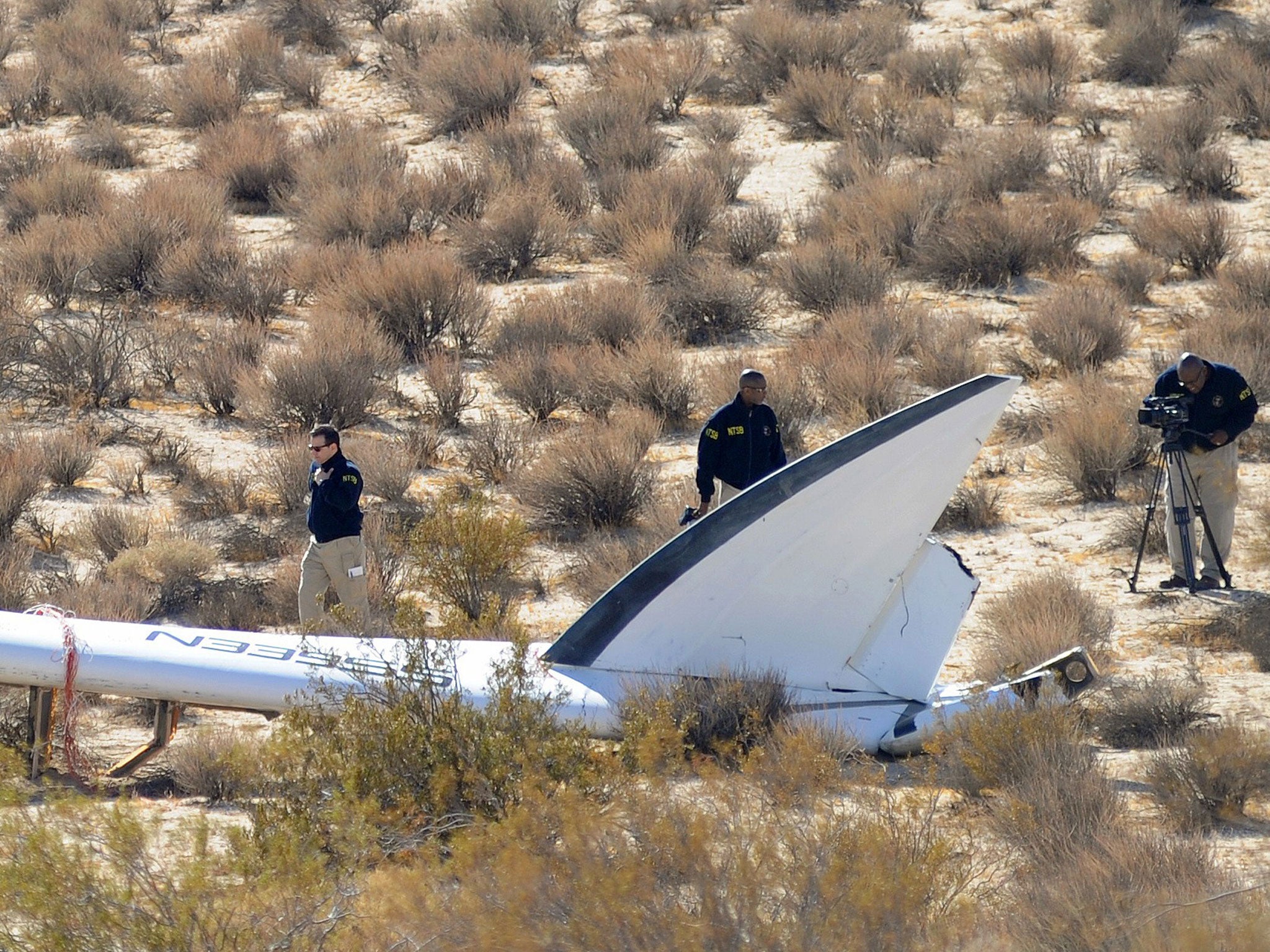A National Transportation Safety Board (NTSB) team surveys a tail section from the crashed Virgin Galactic SpaceShipTwo near Cantil, California