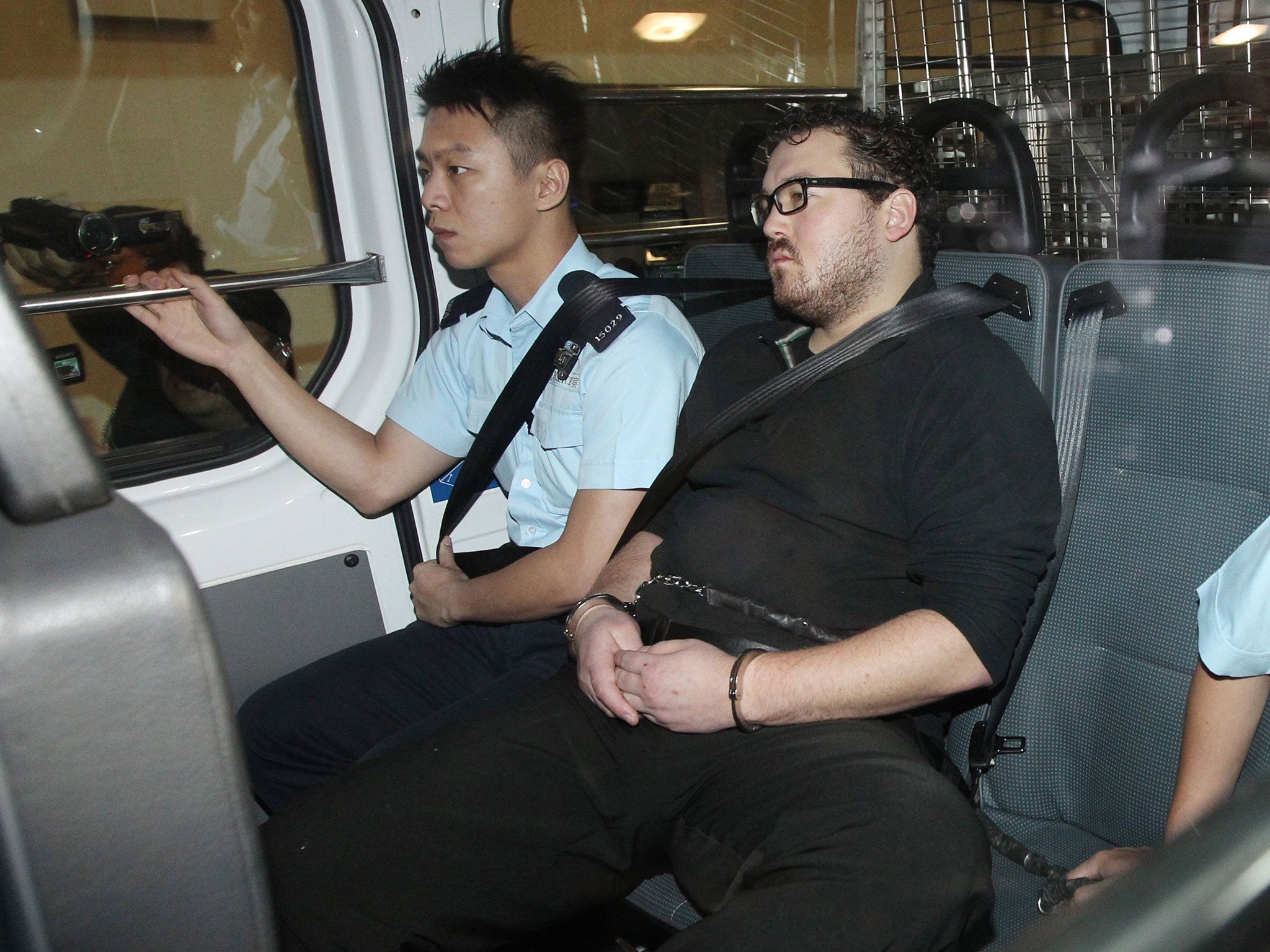 Rurik Jutting is guarded by police on his way to the Eastern Magistrates' Courts in Hong Kong, China, November 3, 2014