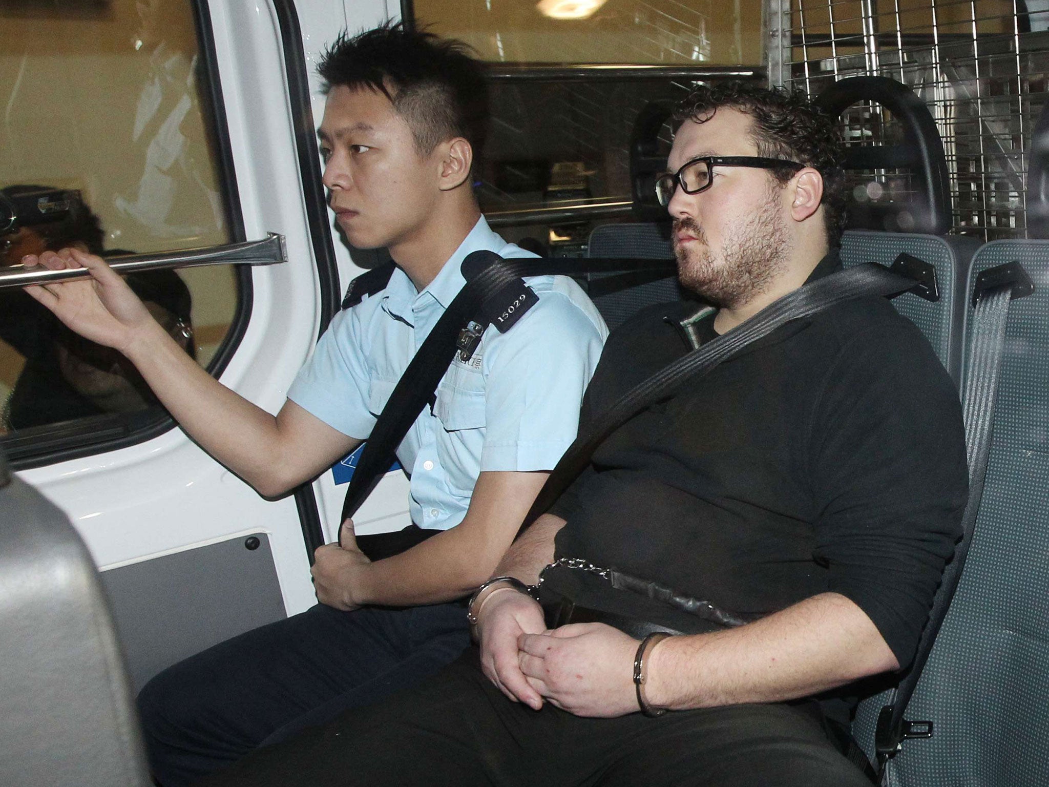 The British expatriate Rurik Jutting being taken to court in Hong Kong, where his lawyer suggested he may co-operate with police over the two murder charges he is facing