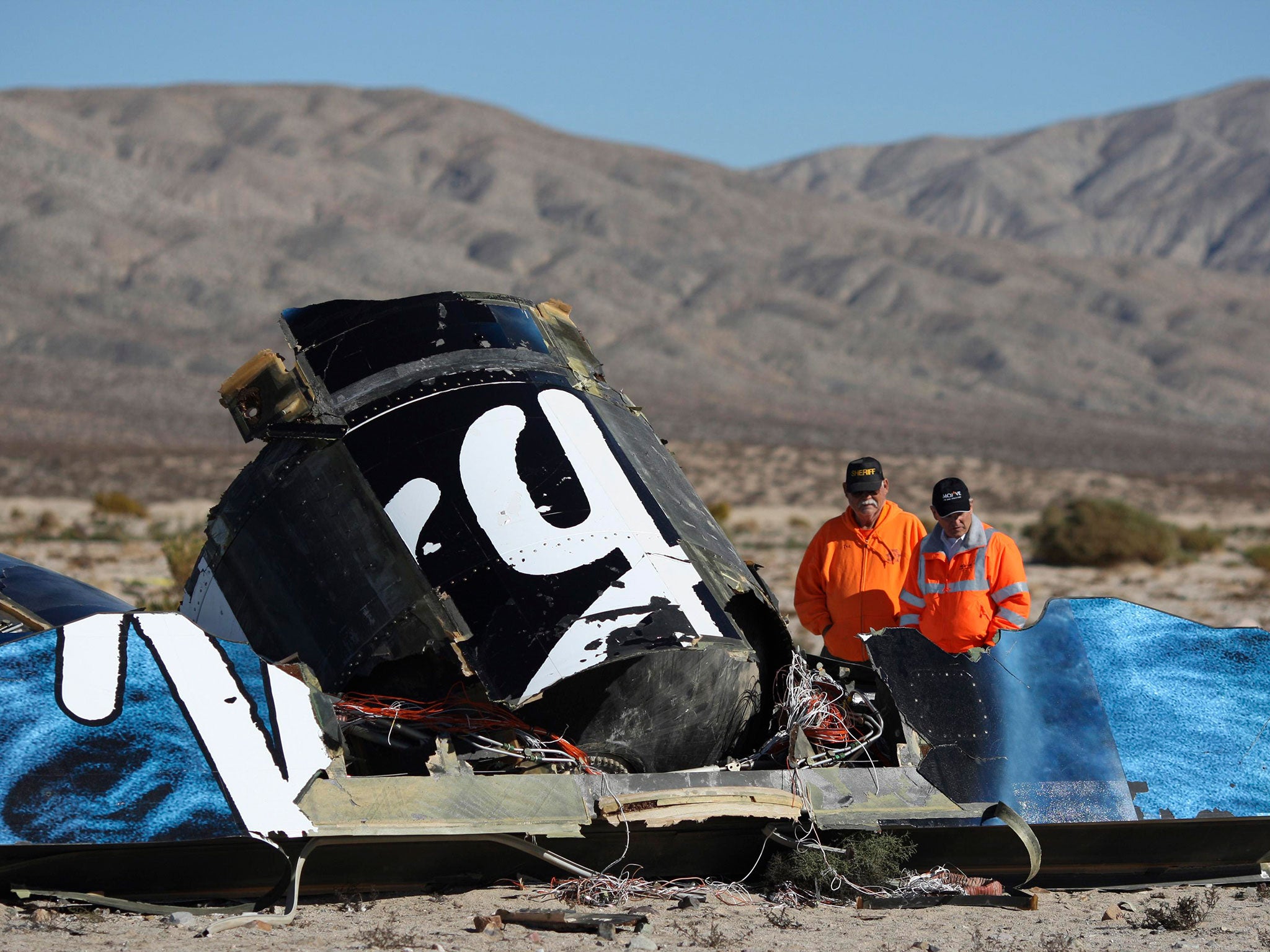 Sheriffs’ deputies look at wreckage from the crash of Virgin Galactic’s