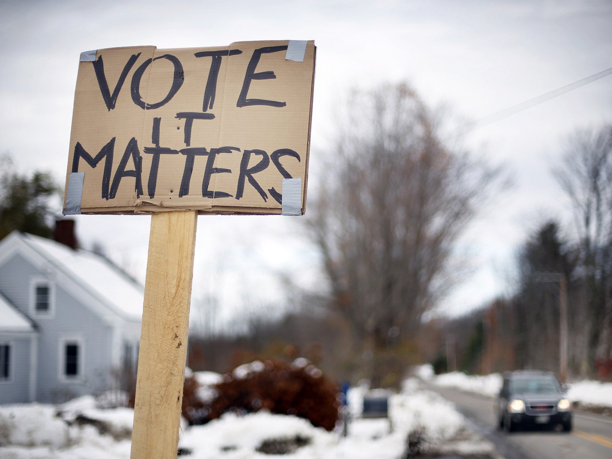 A handmade sign stuck in a snowbank on a rural road urges citizens to vote in Searsmont, Maine