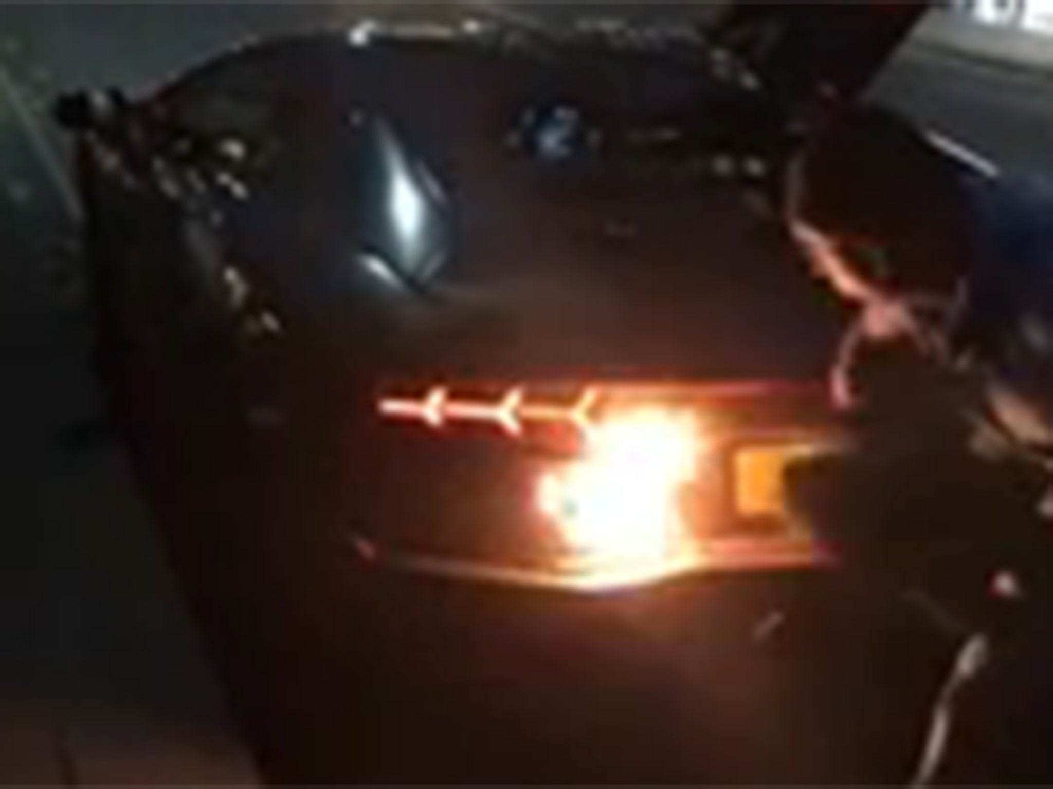 The owner of the Lamborghini tries to stop the fire by using a piece of clothing to swat at it