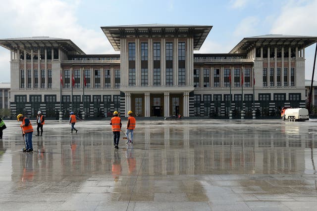 Workers clean the area in front of the new Turkish Presidential Palace prior to an official reception for Republic day in Ankara