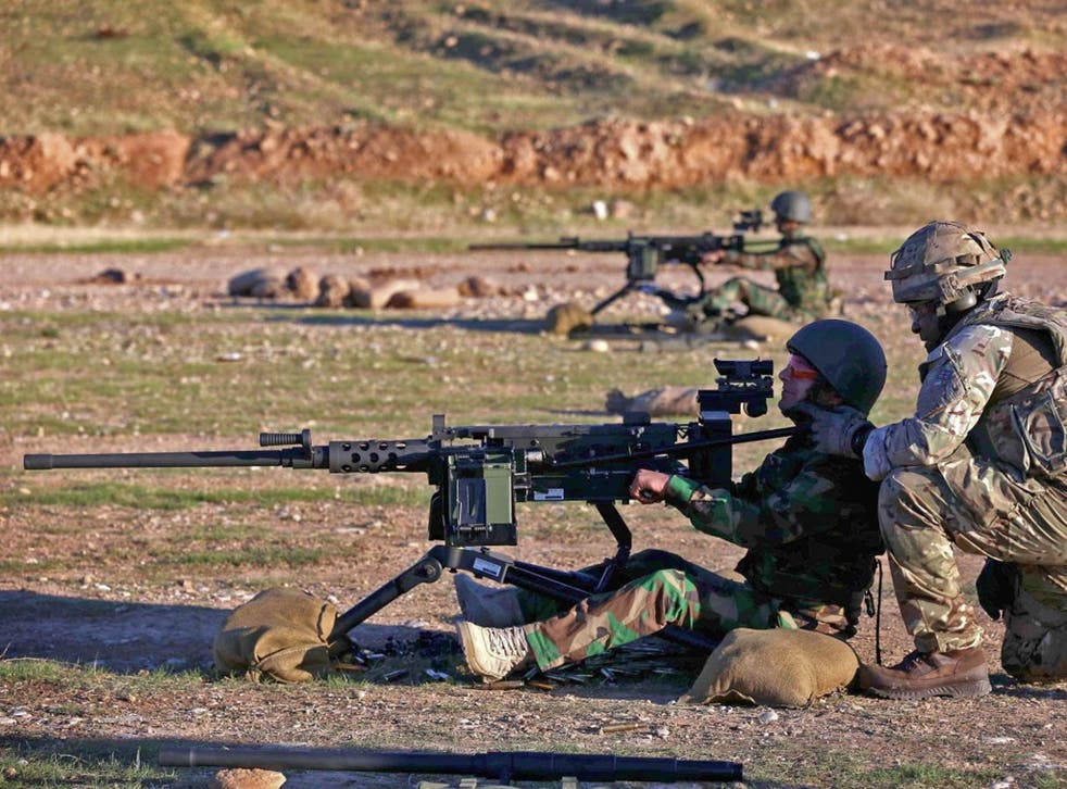 British military advisers instruct Kurdish Peshmerga fighters during a training session at a shooting range in Arbil