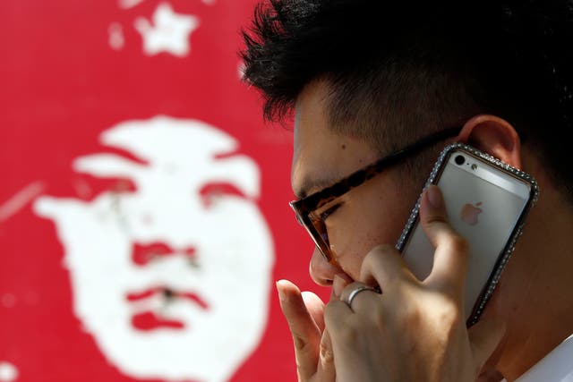 A man talks on an iPhone in Beijing July 24, 2013.