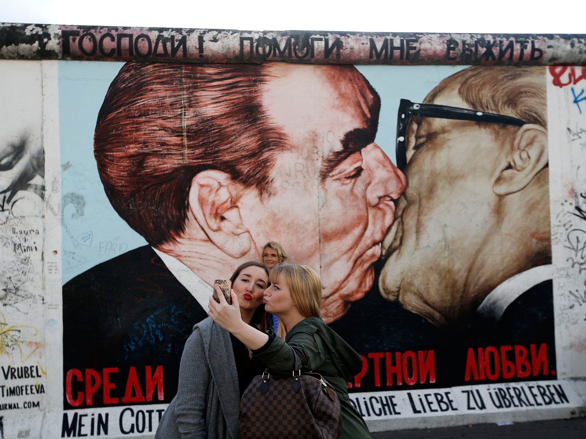 Former Soviet leader Leonid Brezhnev is painted kissing his East German counterpart Erich Honecker (R) on a segment of the East Side Gallery, the largest remaining part of the former Berlin Wall in Berlin