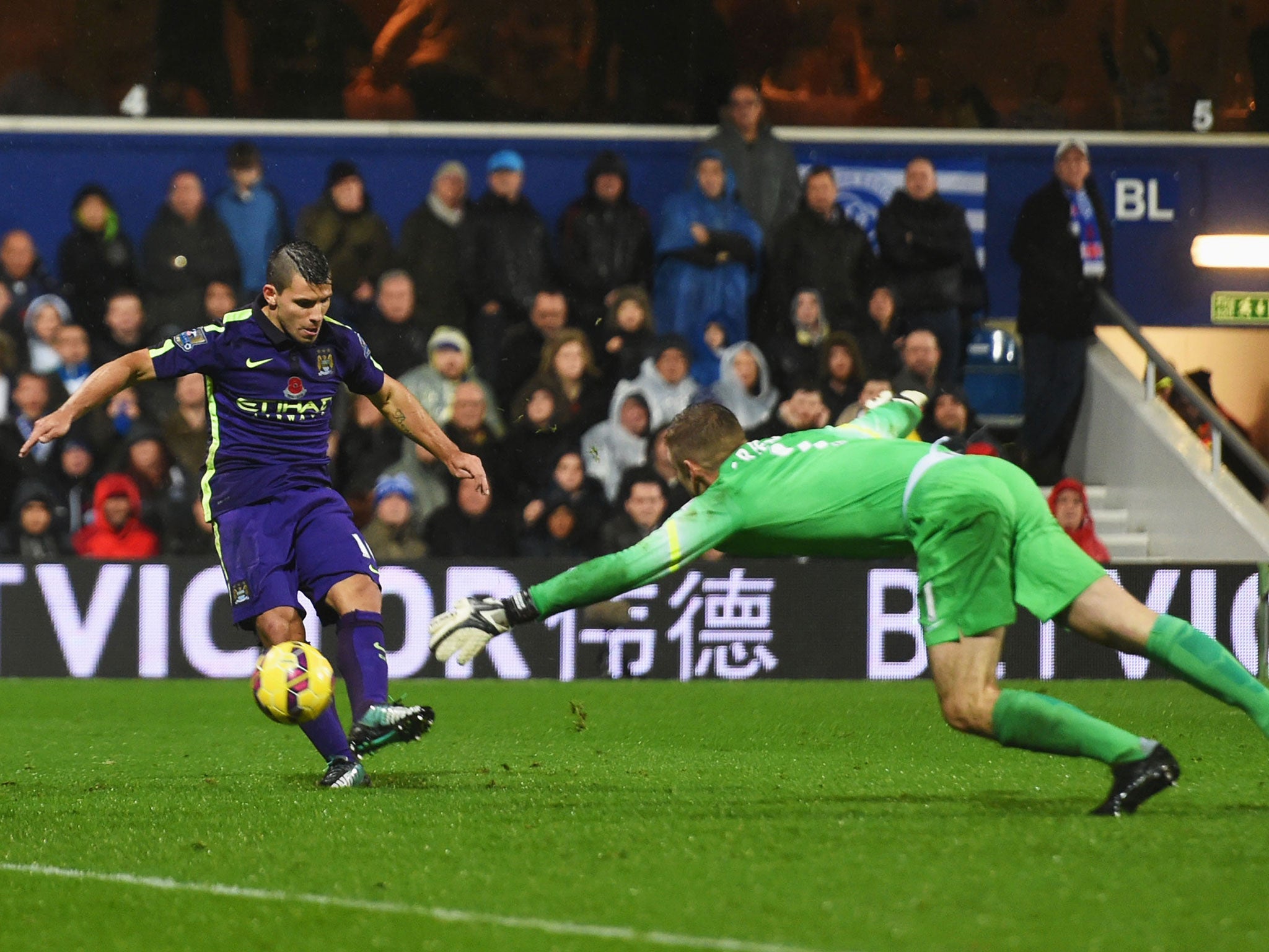 Sergio Aguero scores as he places the ball past Rob Green